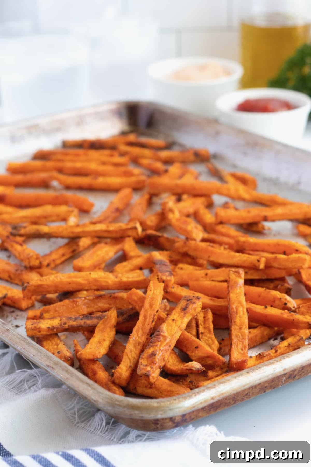 A rimmed baking sheet filled with freshly baked sweet potato fries