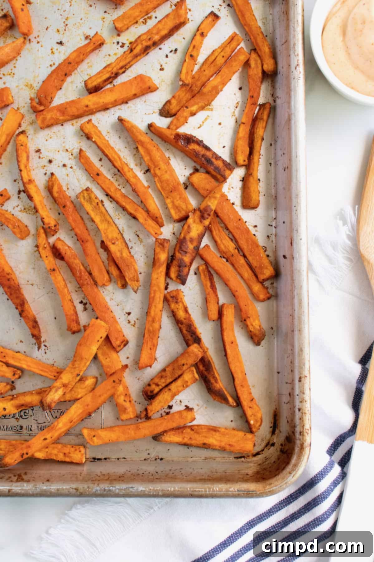 Crispy baked sweet potato fries artfully arranged on a baking sheet