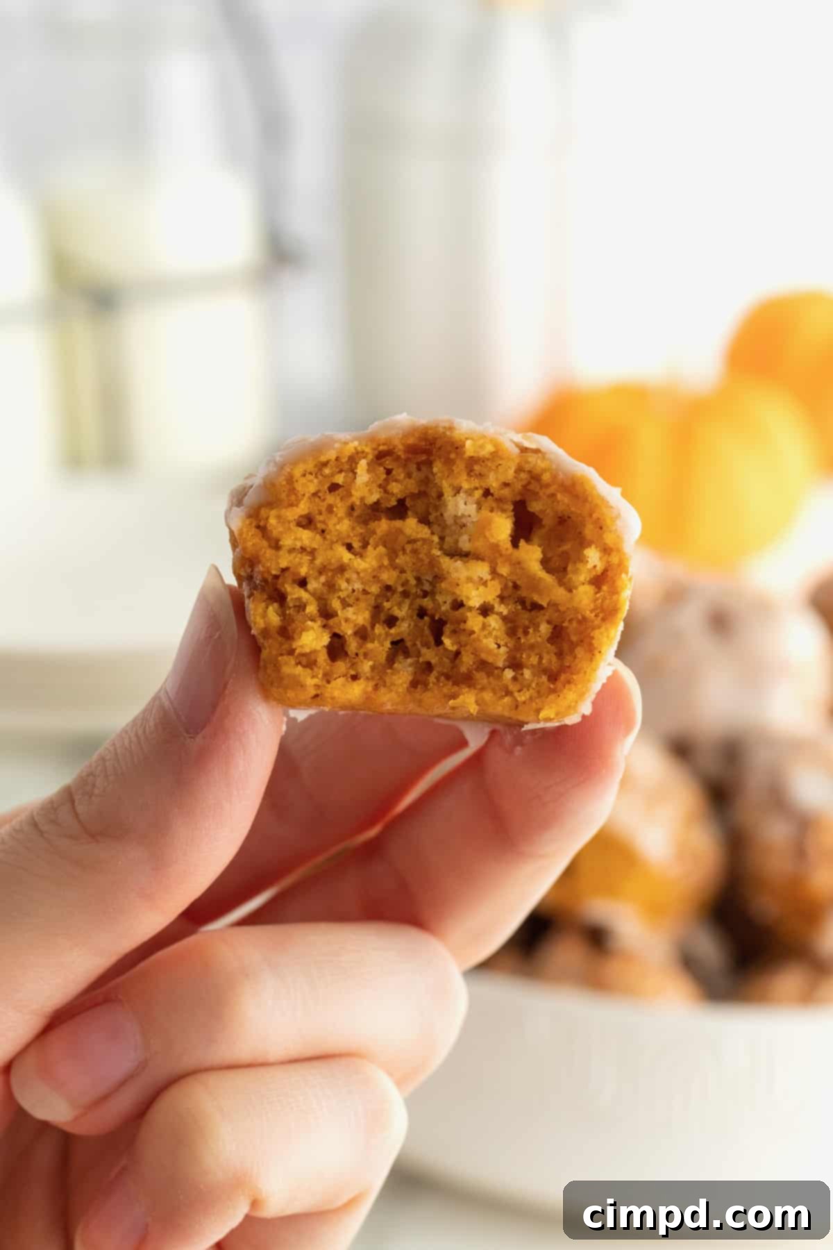 Baked Pumpkin Poppers 3 An overhead shot showcasing multiple baked pumpkin fritter bites, highlighting their golden-brown exterior and generous glaze.