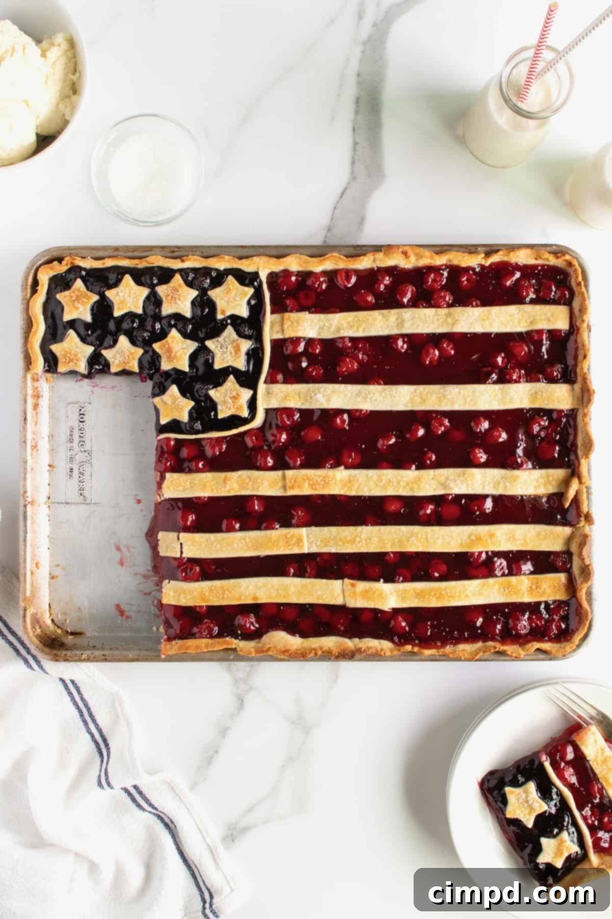 Stars and Stripes Pie 4 Overhead shot of an American Flag Pie on a baking sheet, showcasing the unbaked flag design with cherry stripes and blueberry stars.