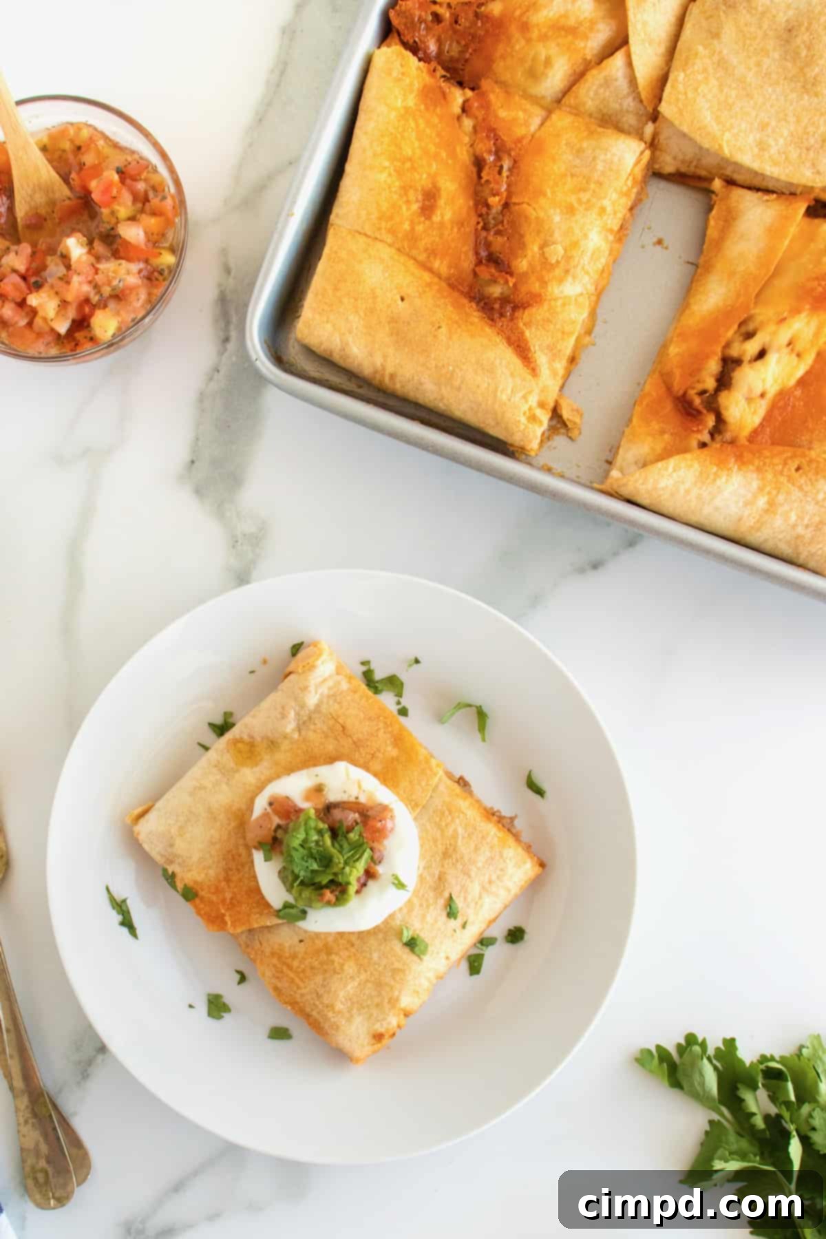 Close-up of a slice of Beef and Bean Sheet Pan Quesadilla with toppings
