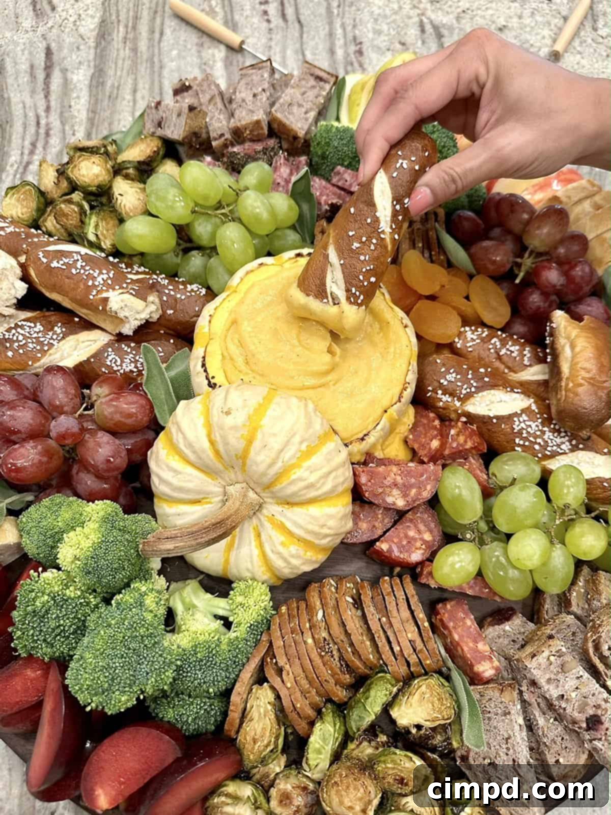 Close-up of the Fall Fondue Board, highlighting the melted cheese within the pumpkin and some of the delicious dippers.