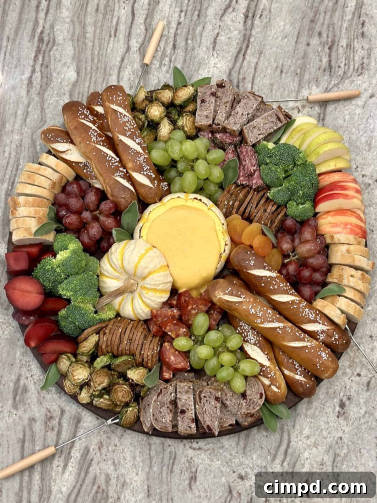 A close-up view of the melted cheese fondue in the baked pumpkin bowl on the Fall Fondue Board, surrounded by delicious dippers.