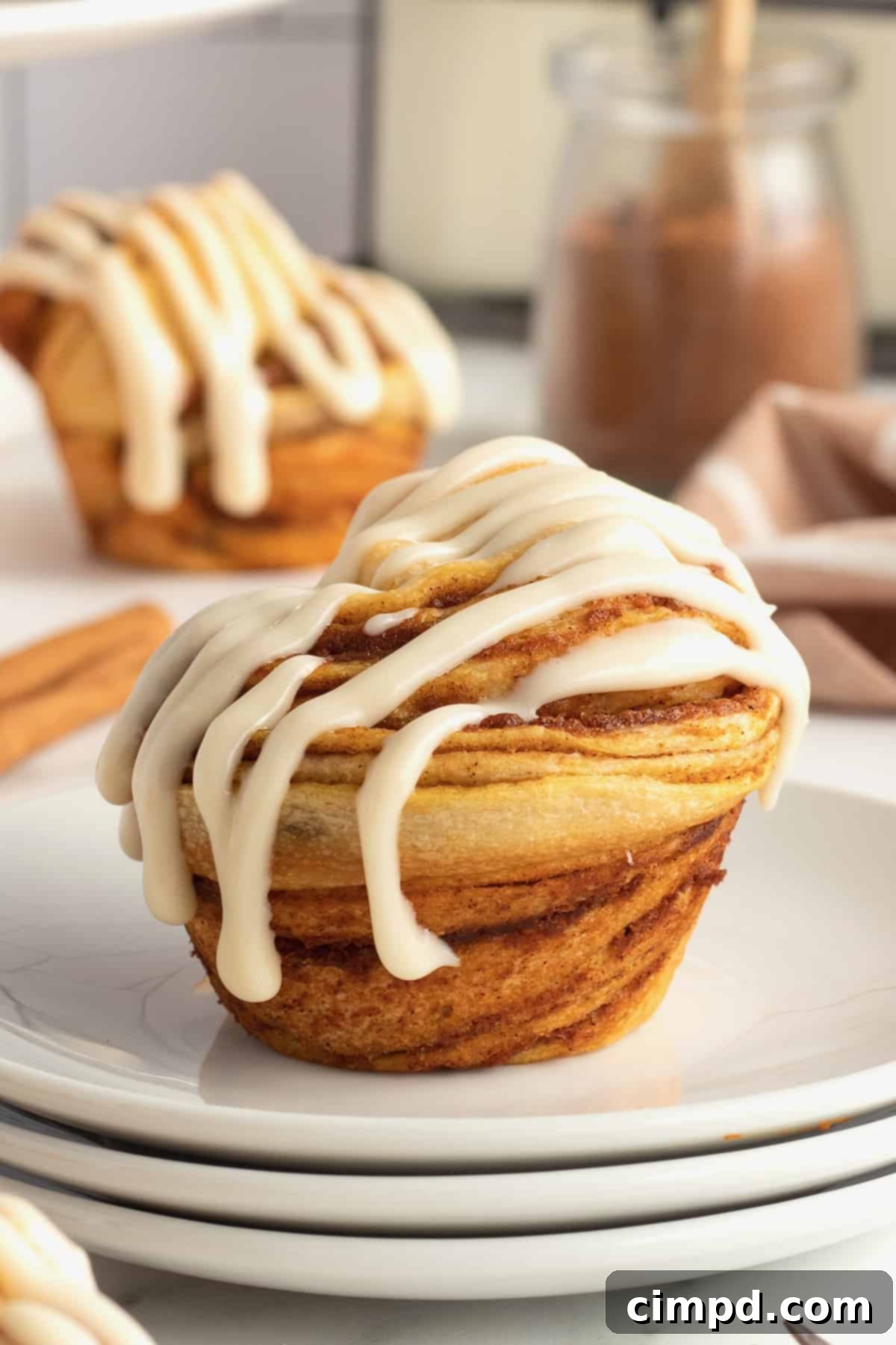 Spiced Pumpkin Cruffins 2 Close-up of a beautifully glazed Pumpkin Spice Cruffin, showcasing its flaky layers and inviting autumn colors. Ideal for fall baking enthusiasts.