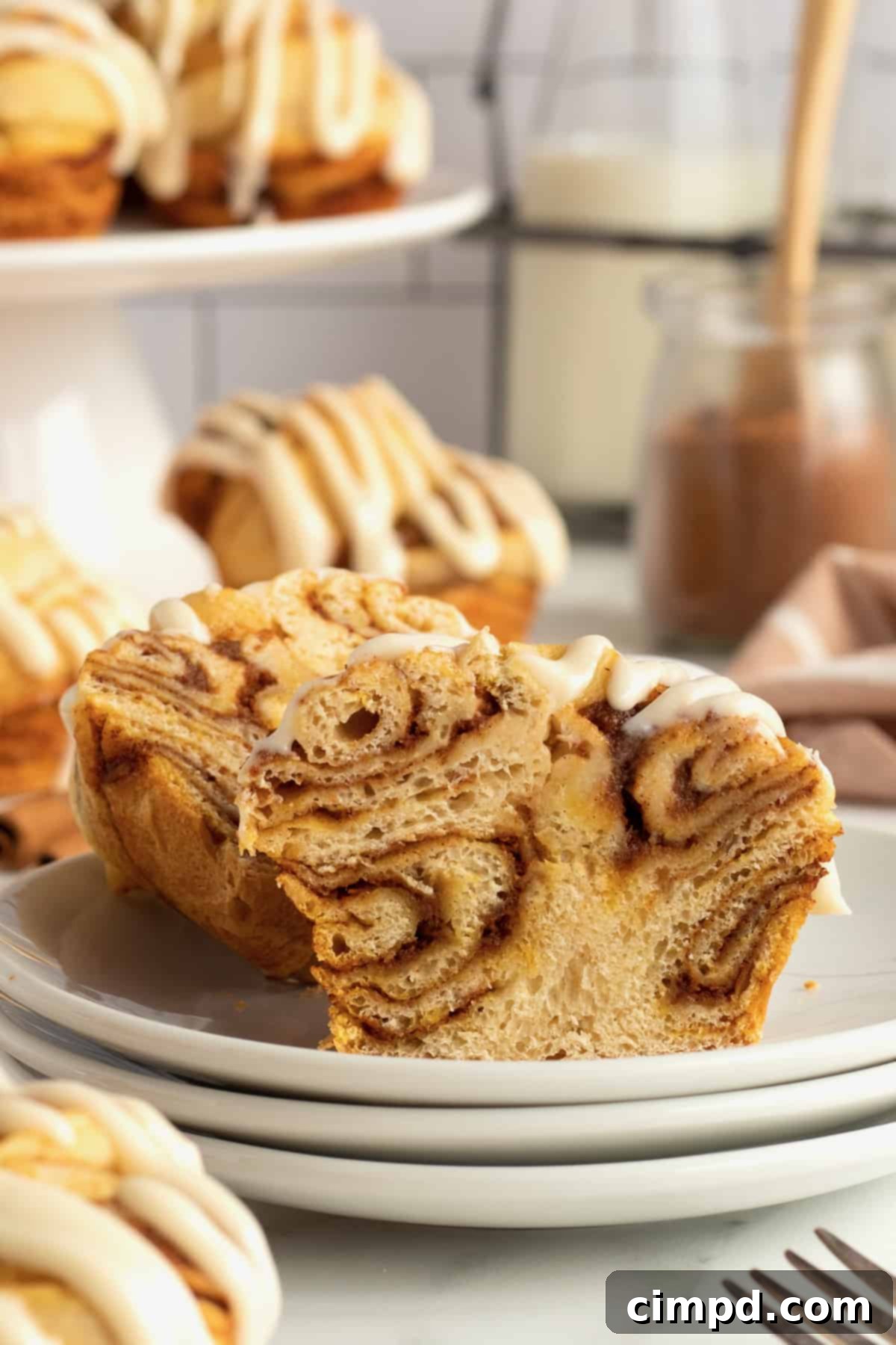 Spiced Pumpkin Cruffins 3 Stack of Pumpkin Spice Cruffins, showcasing their golden-brown tops and generous cream cheese glaze drizzle. Perfect for a cozy fall morning.
