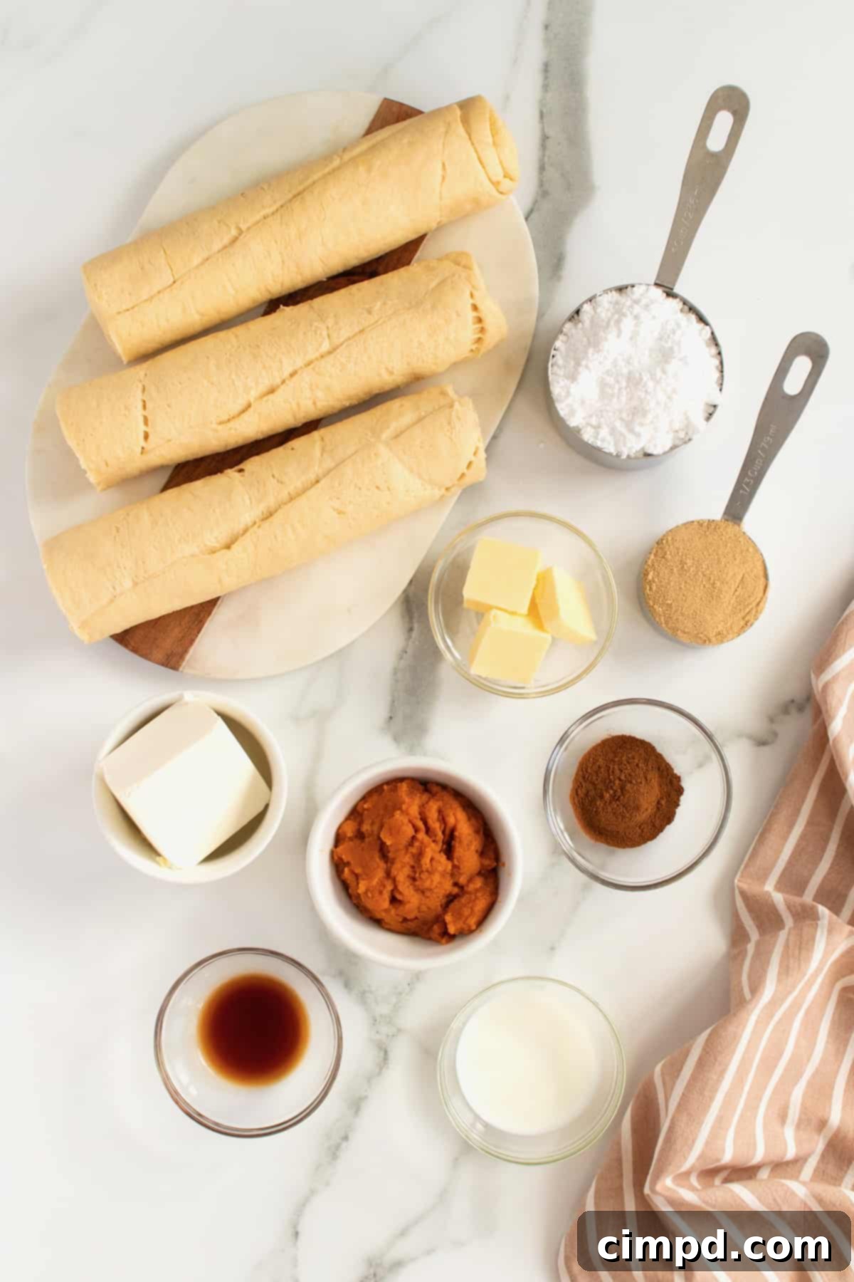 Spiced Pumpkin Cruffins 4 Selection of fresh ingredients for Pumpkin Spice Cruffins including crescent roll dough, pumpkin puree, spices, and cream cheese, arranged on a kitchen counter.