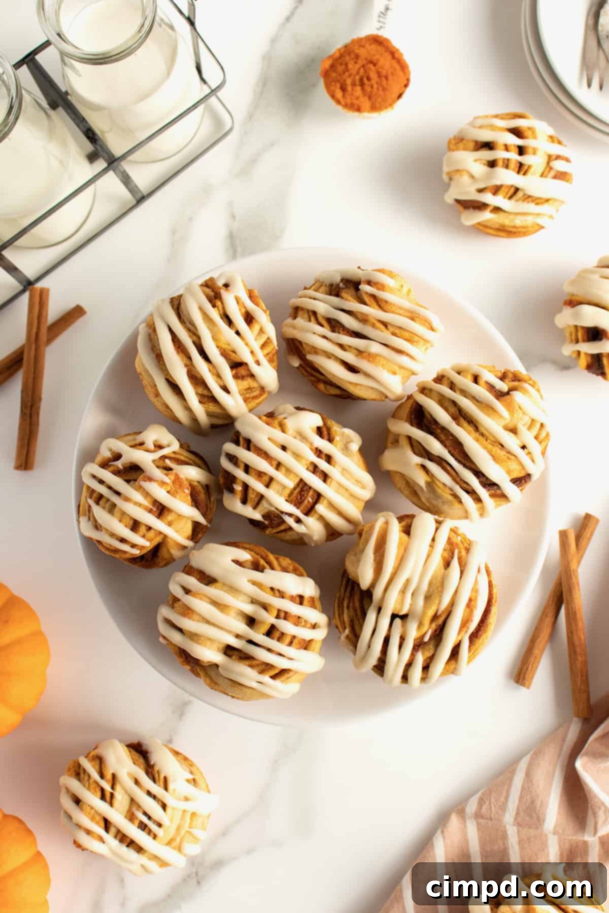 Spiced Pumpkin Cruffins 8 A top-down shot of a single Pumpkin Spice Cruffin, showcasing its beautiful spiral shape, flaky texture, and generous cream cheese glaze.