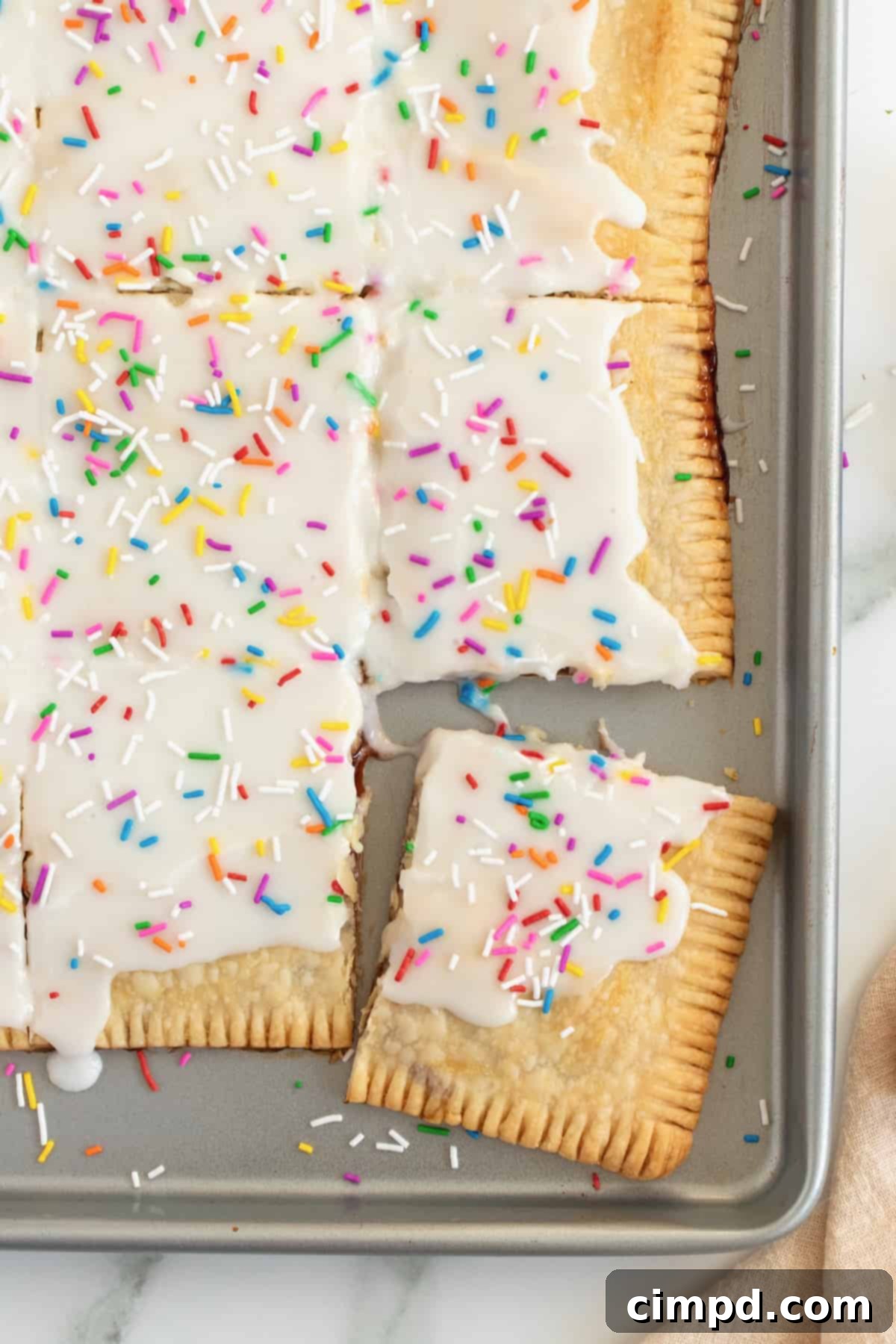 Easy Homemade Strawberry Sheet Pan Pop Tart 5 Sliced homemade strawberry sheet pan pop tart, showing off its golden crust, sweet strawberry filling, and delicate icing, ready to be served.