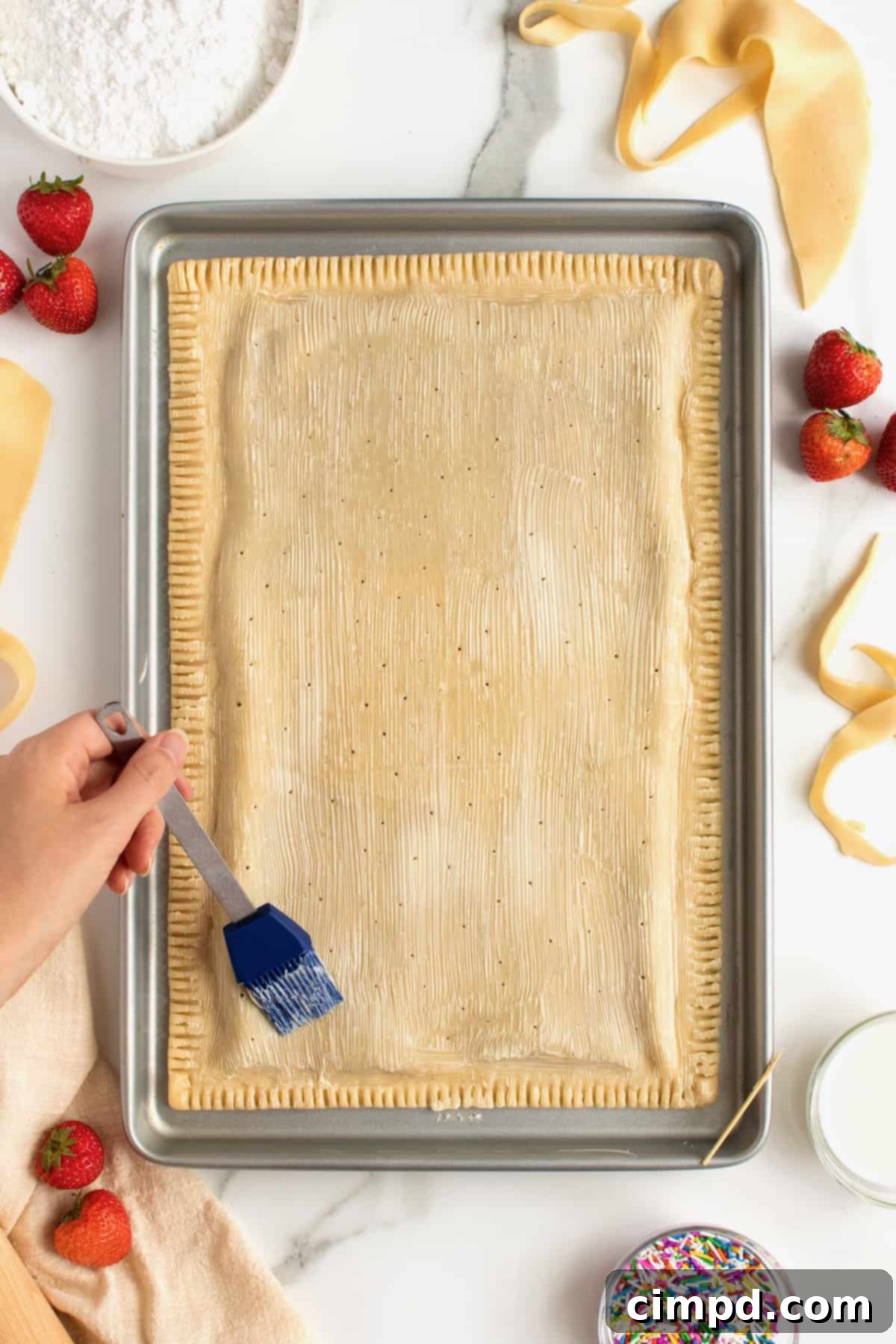 Easy Homemade Strawberry Sheet Pan Pop Tart 7 The homemade strawberry sheet pan pop tart in the oven, baking to a perfect golden brown, with buttered crust and vents.