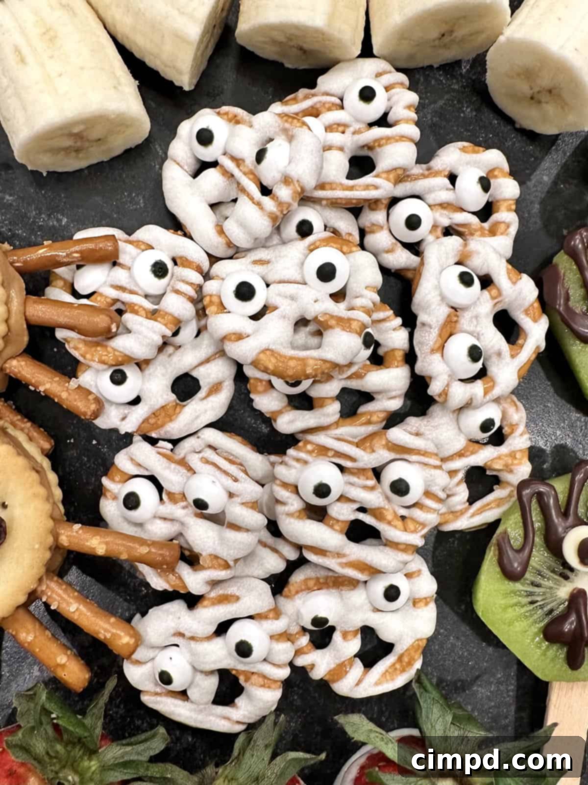 5 Spooktacularly Cute Halloween Goodies 9 Adorable Mummy Pretzels, drizzled with white candy coating and decorated with candy eyeballs, a perfect spooky cute Halloween treat.