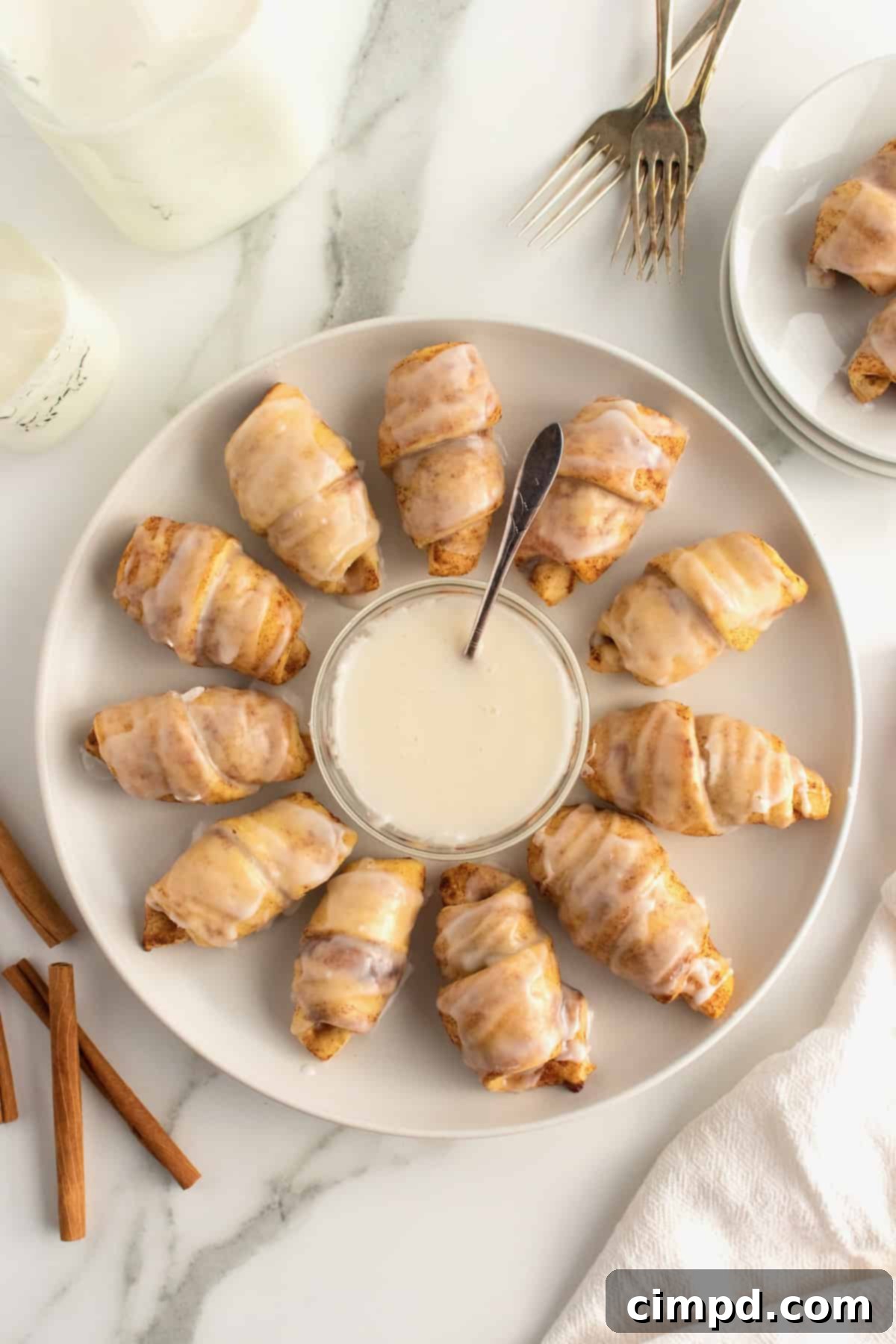 Cinnamon Roll Pigs in a Blanket, fresh out of the oven, covered in sweet glaze.