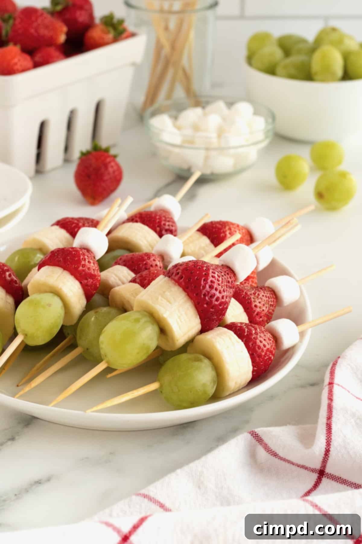 Grinch Fruit Skewers stored neatly in an airtight container in the refrigerator, ready for later consumption.