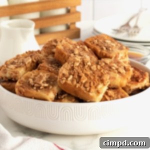 Cinnamon Toast Crunch French Toast Poppers 11 A white serving bowl filled with French toast bites covered in crushed Cinnamon Toast Crunch cereal.