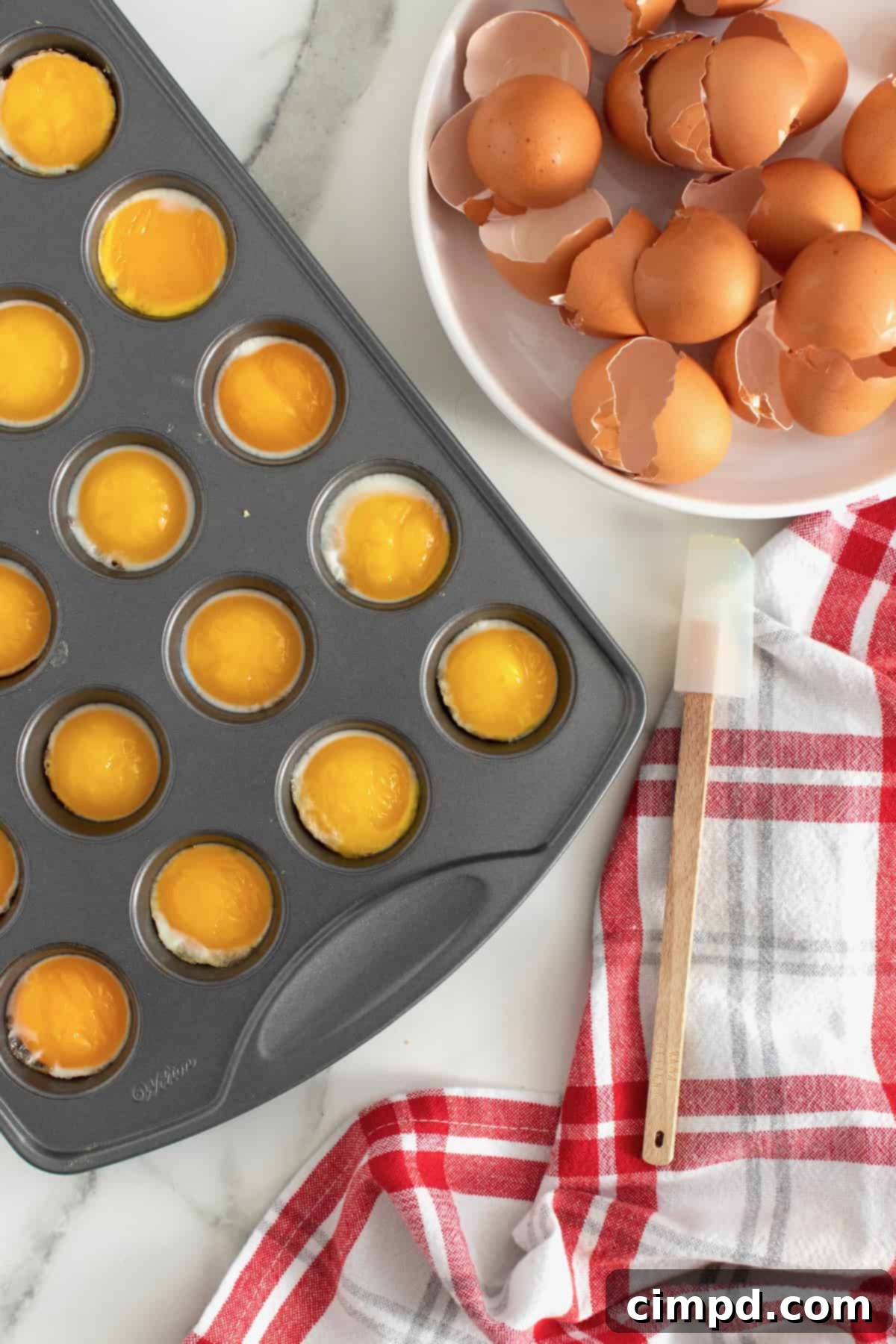 Bake Perfect Runny Eggs in Your Mini Muffin Pan 4 A plate of perfectly cooked runny eggs from a muffin tin, served with various breakfast items, by The BakerMama