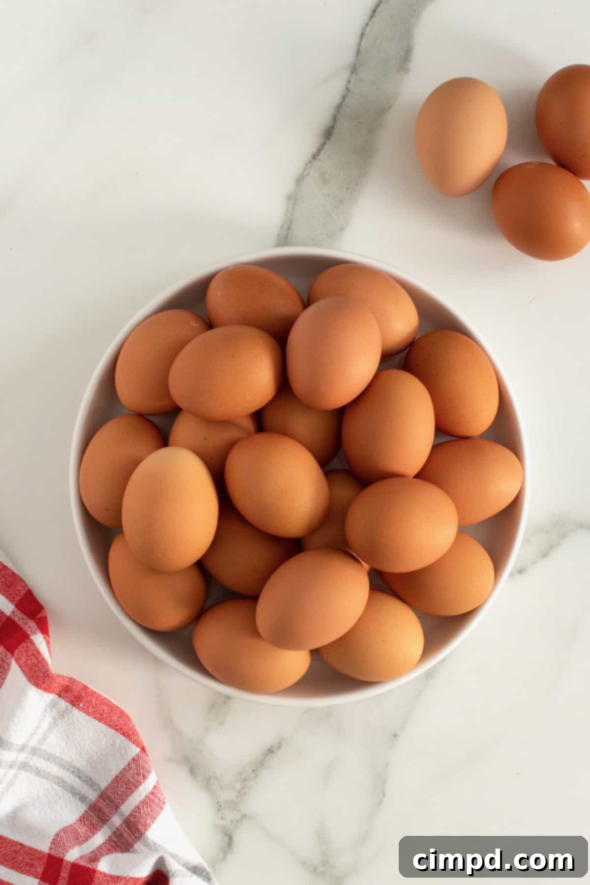 Bake Perfect Runny Eggs in Your Mini Muffin Pan 5 Ingredients and supplies laid out for making muffin tin runny eggs: eggs, a mini muffin pan, and cooking spray by The BakerMama