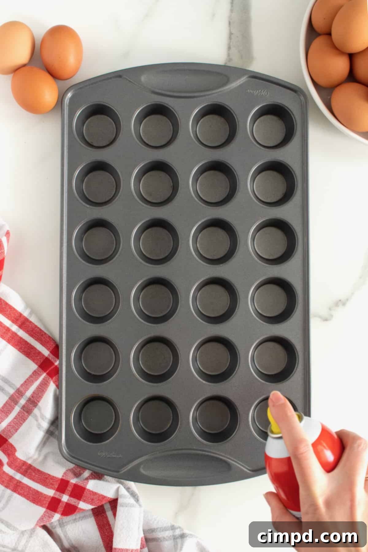 Bake Perfect Runny Eggs in Your Mini Muffin Pan 6 Mini muffin pan sprayed with non-stick cooking spray, ready for eggs by The BakerMama