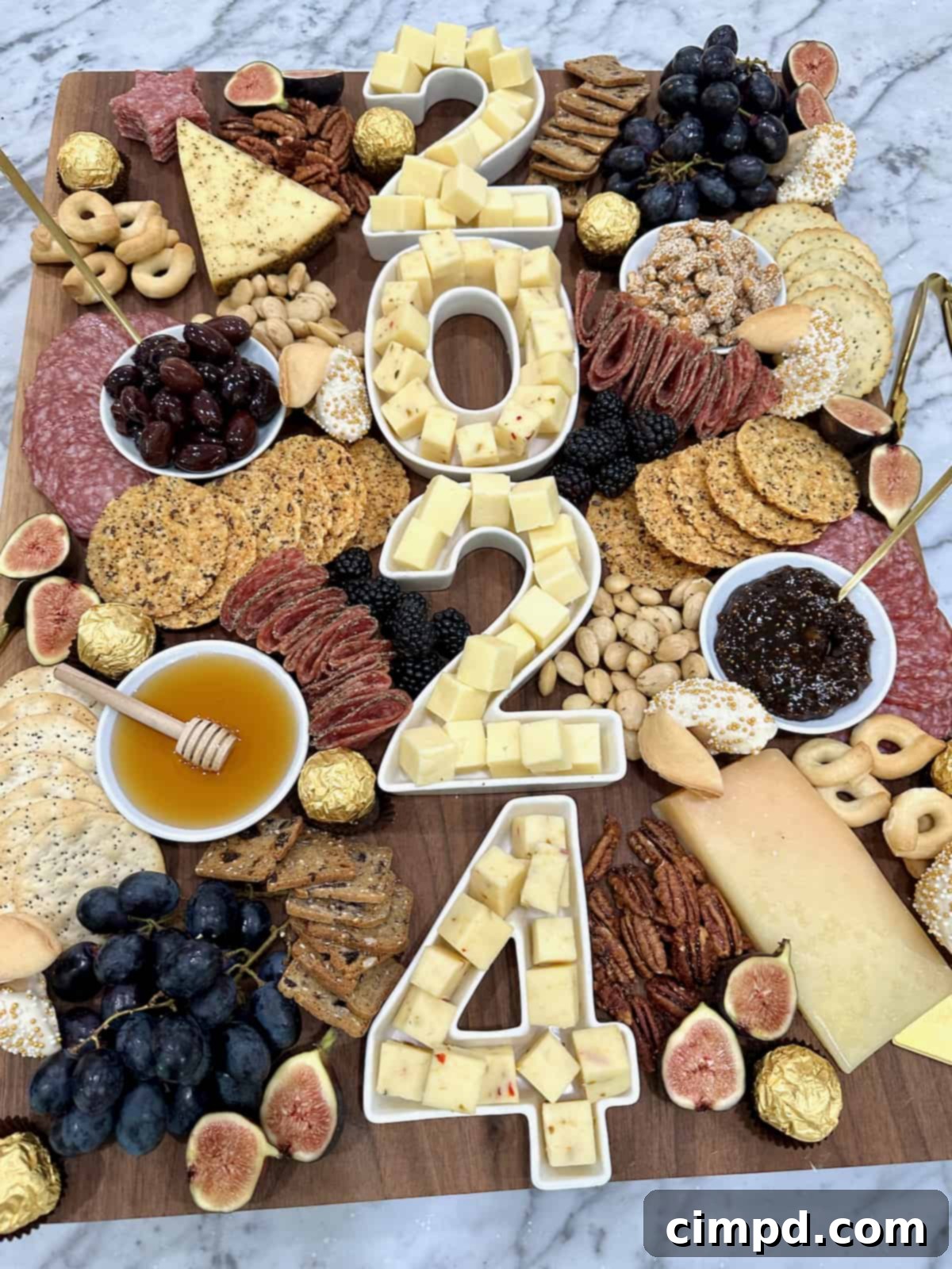 Gourmet NYE Cheese Spread 4 A large wood cheese board with 2024 spelled out in number dishes full of white cheese cubes.