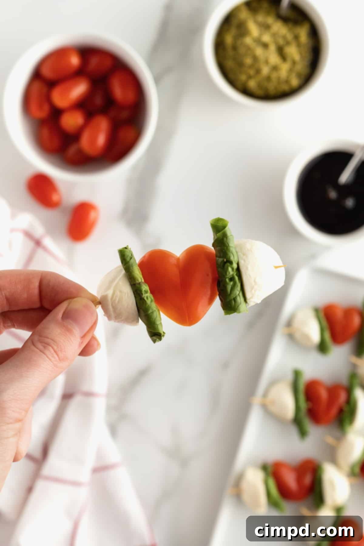 Platter of finished Cupid's Caprese Kabobs with balsamic glaze and pesto for dipping