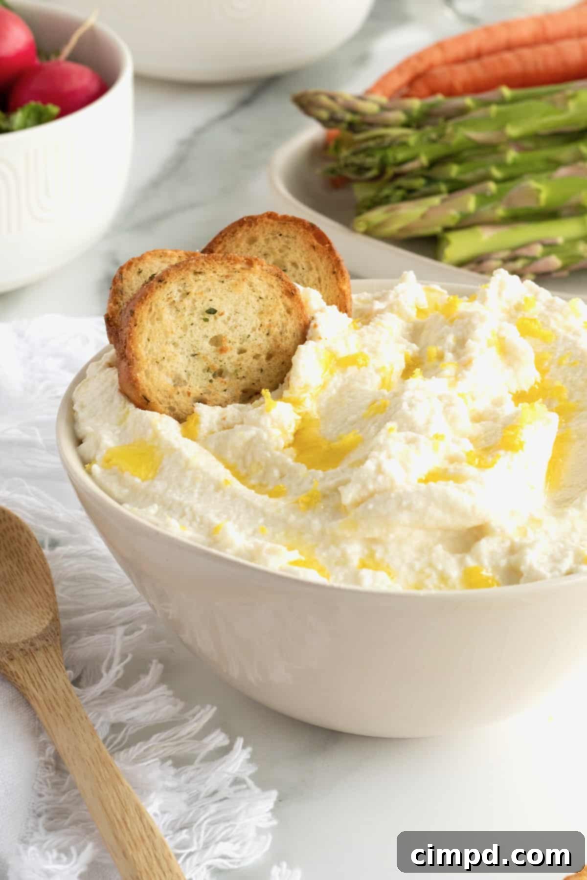 Silky smooth whipped ricotta spread garnished with a drizzle of olive oil, ready to be served.