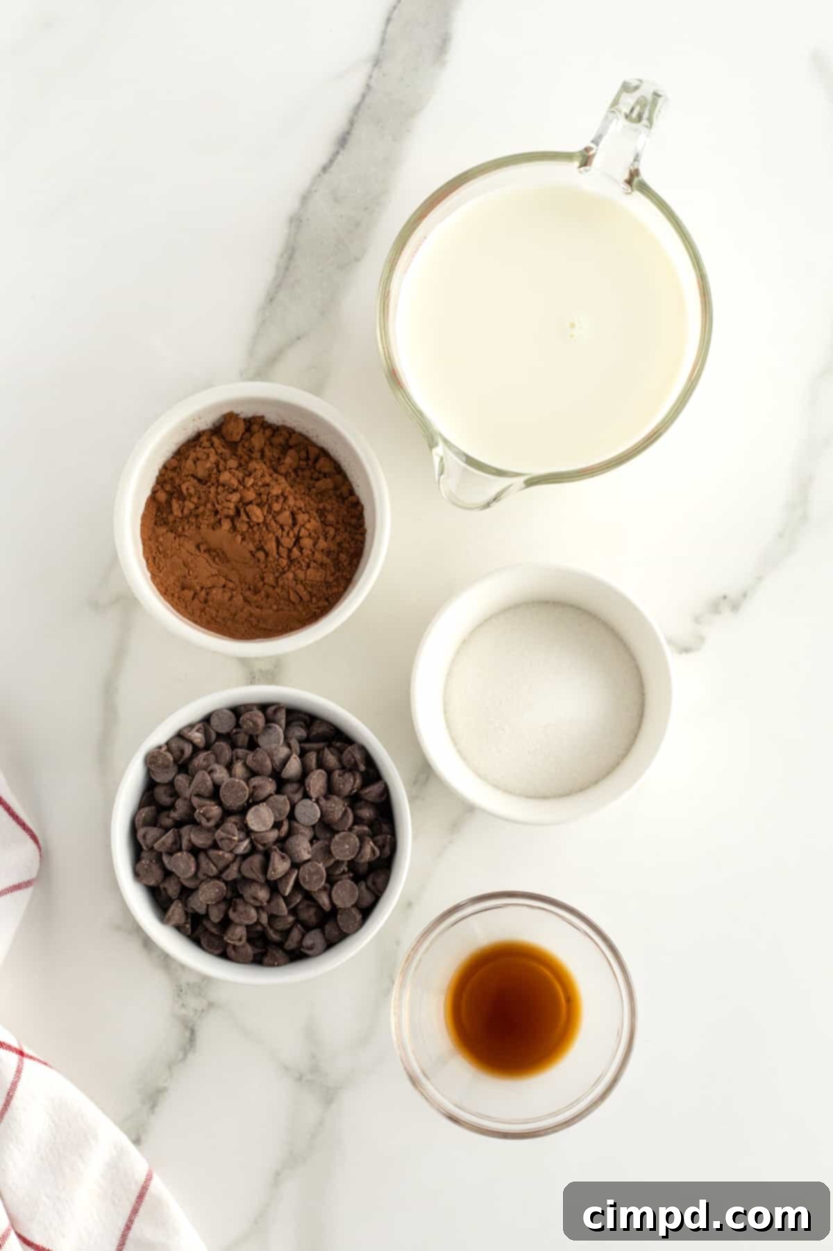 A selection of ingredients for Homemade Hot Chocolate, including milk, chocolate chips, cocoa powder, and sugar.