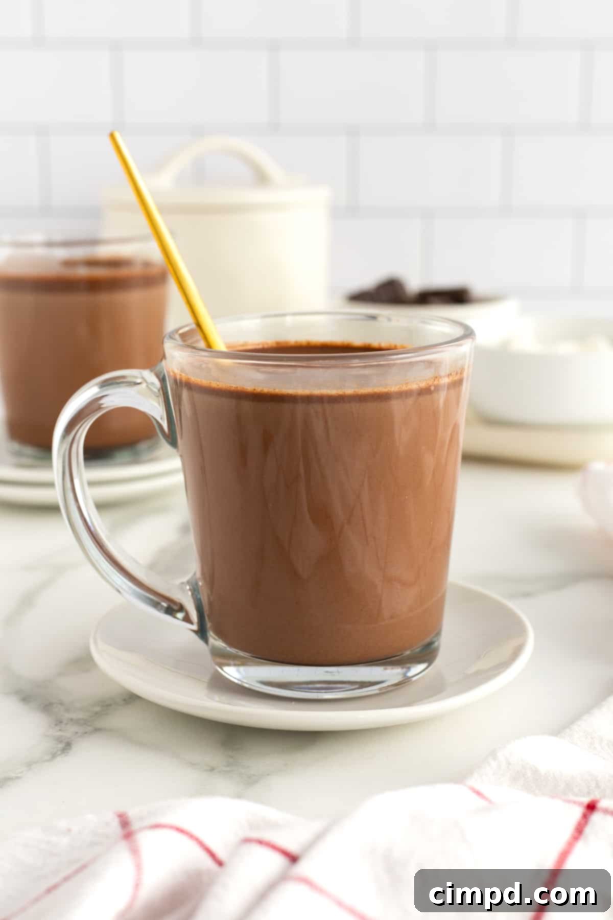 A large pot of Homemade Hot Chocolate being stirred on the stove, ready for serving.
