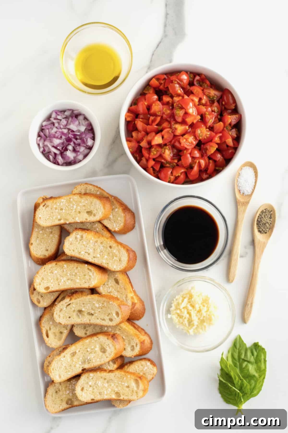 All the fresh ingredients for Classic Tomato Bruschetta laid out on a cutting board.