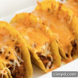 Square image of crispy Beef and Bean Baked Tacos with melted cheese and fresh herbs, ready to serve, by The BakerMama