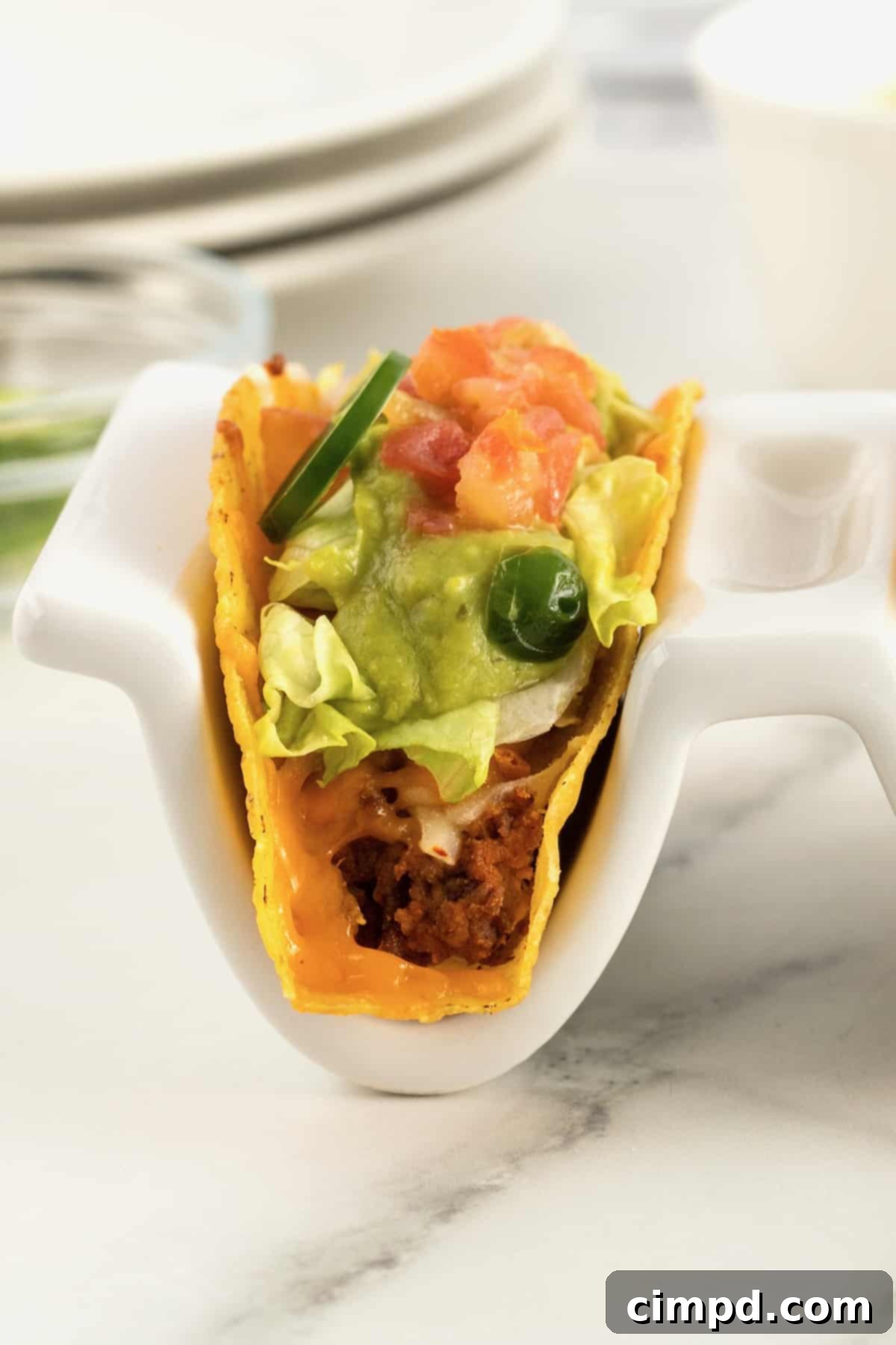 A tray of seven Beef and Bean Baked Tacos lined up in a baking dish, ready to be served, by The BakerMama