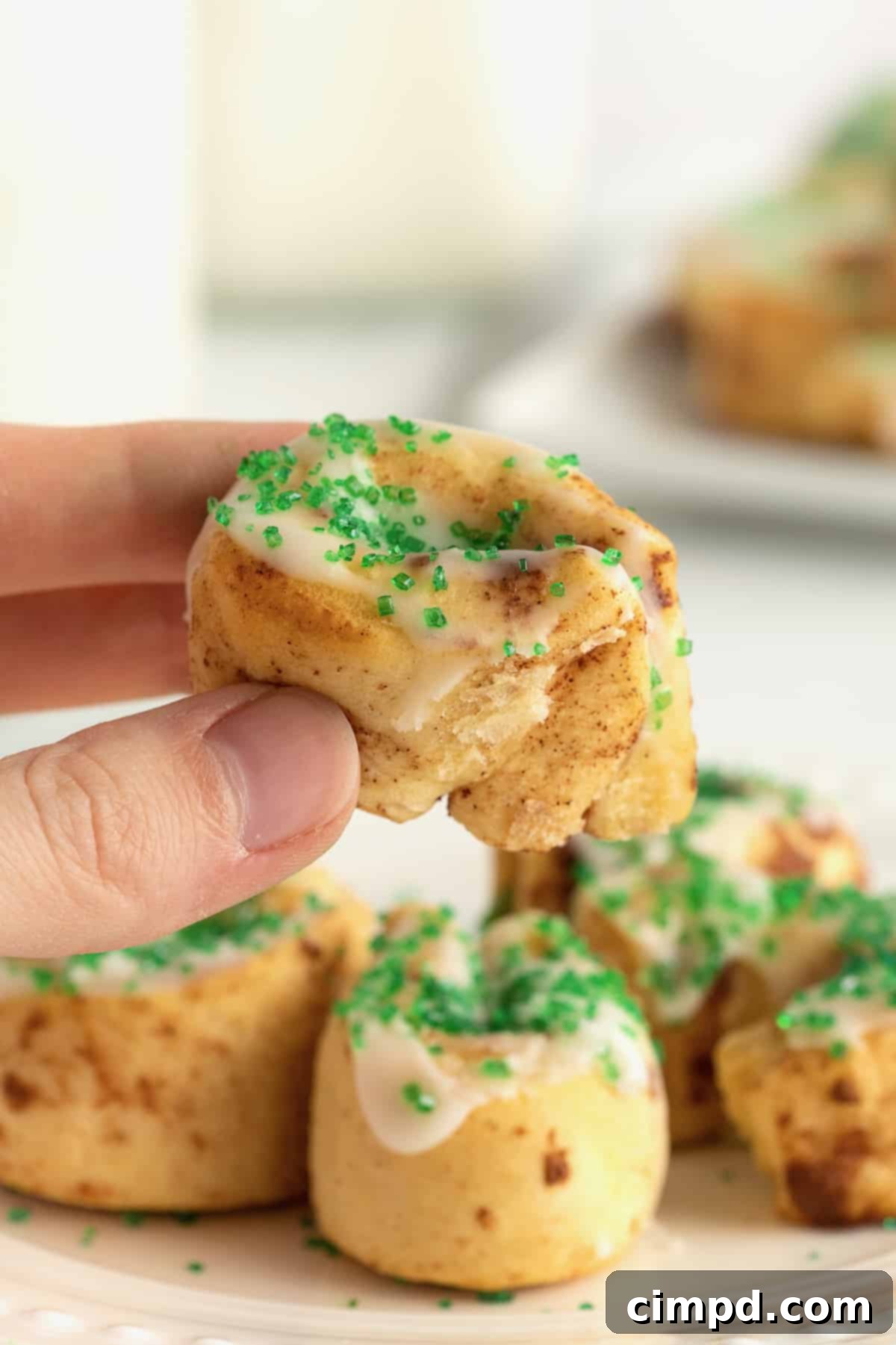 Child's hands reaching for freshly baked St. Patrick's Day Cinnamon Rolls