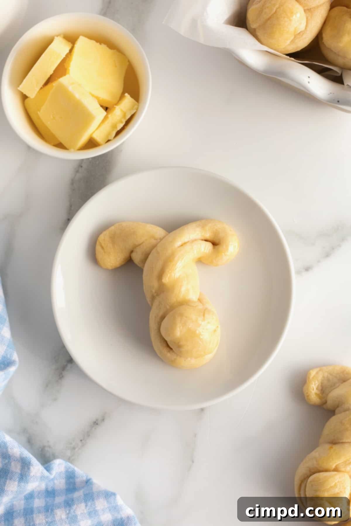 Fluffy Bunny Crescent Rolls 3 Close-up of a single golden brown bunny shaped crescent dinner roll on a plate, highlighting its cute design