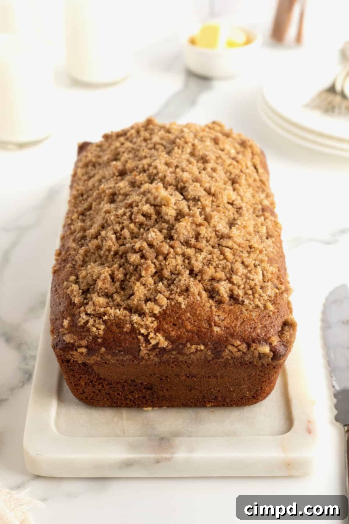 A single slice of Maple Cinnamon Streusel Bread, perfectly golden, sitting on a wooden cutting board.