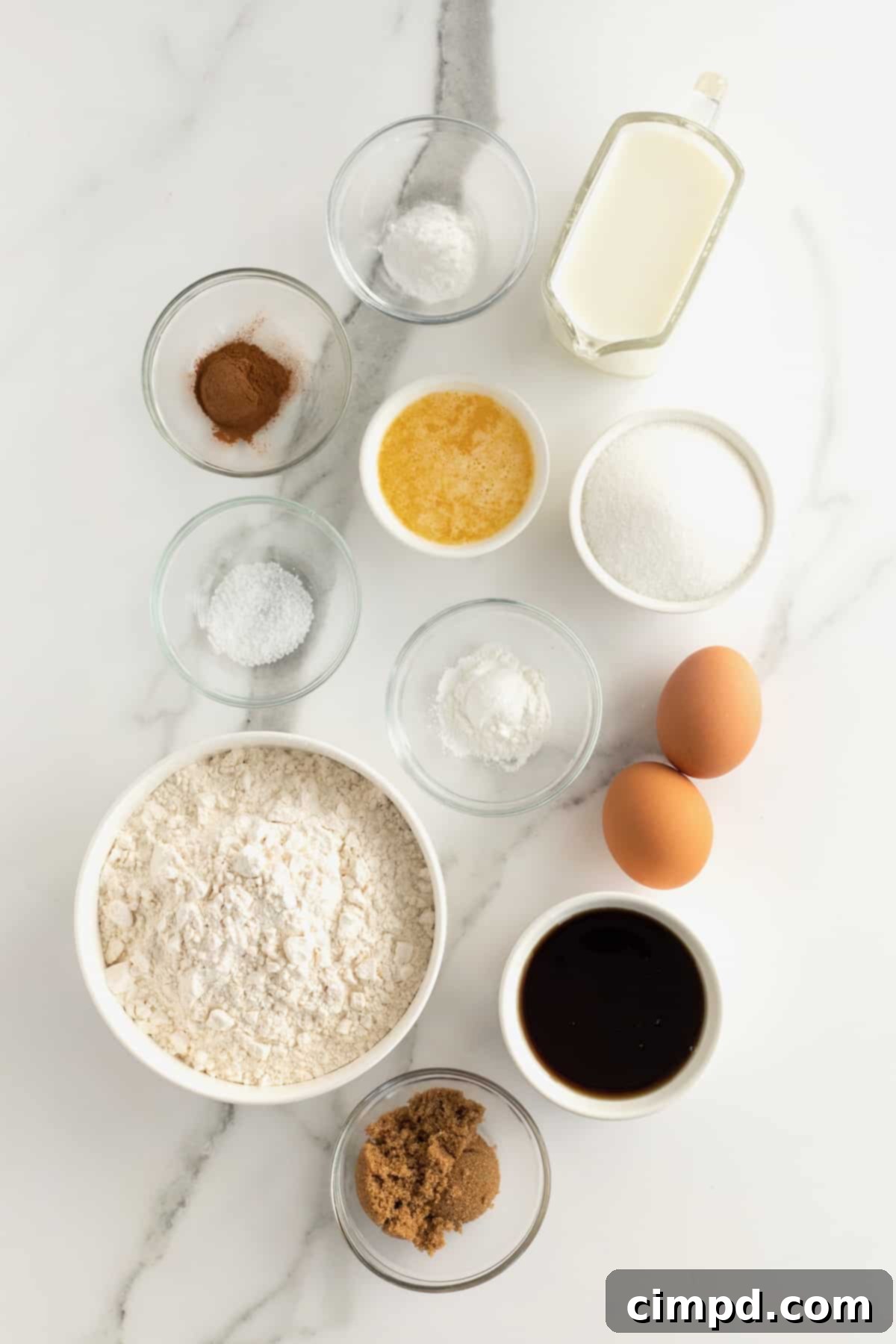 Collection of baking ingredients for Maple Cinnamon Streusel Bread, including flour, eggs, maple syrup, and spices.