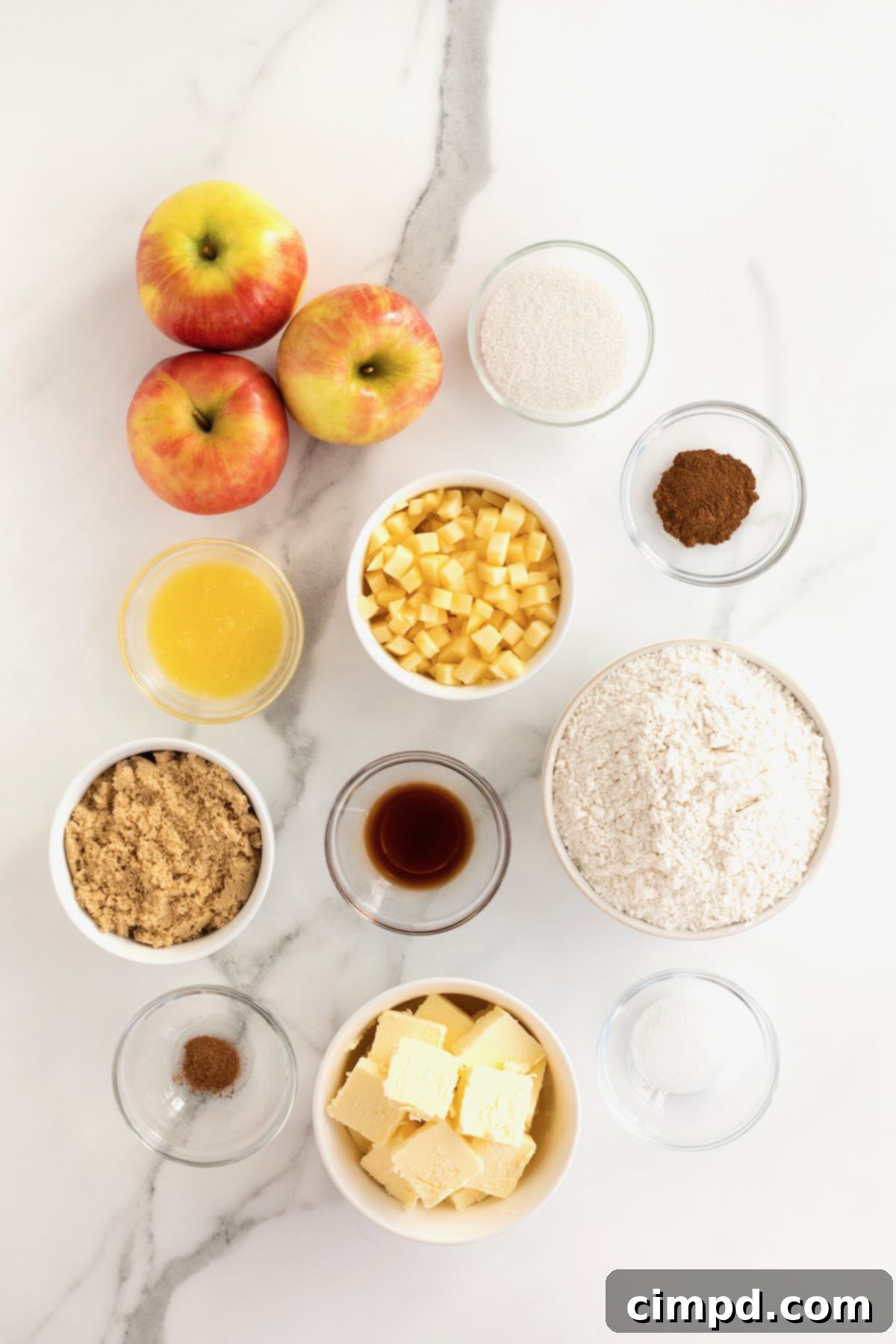 All the ingredients for apple pie bites in small glass dishes on a white counter top.