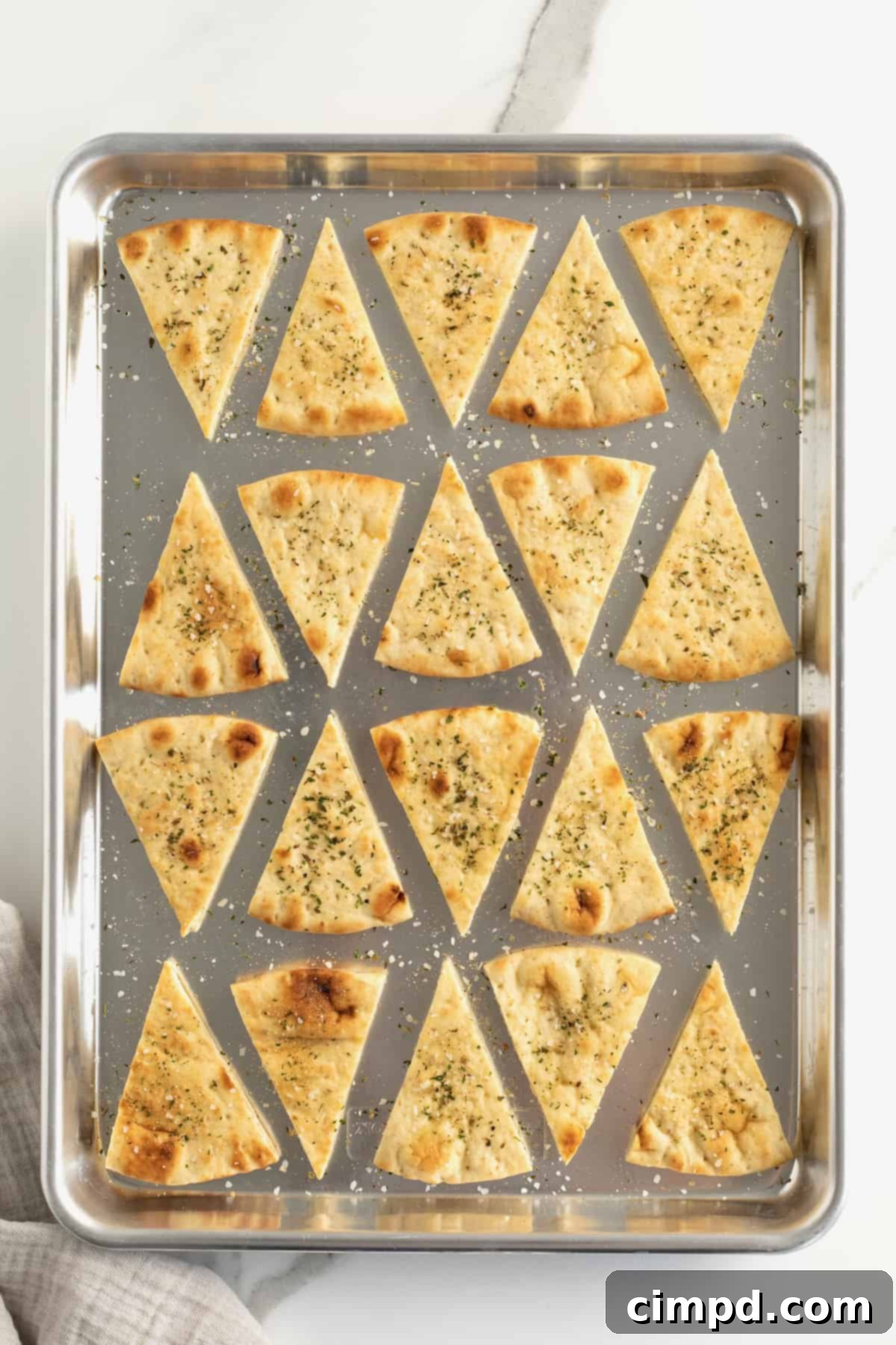 Freshly baked pita chips cooling on a wire rack