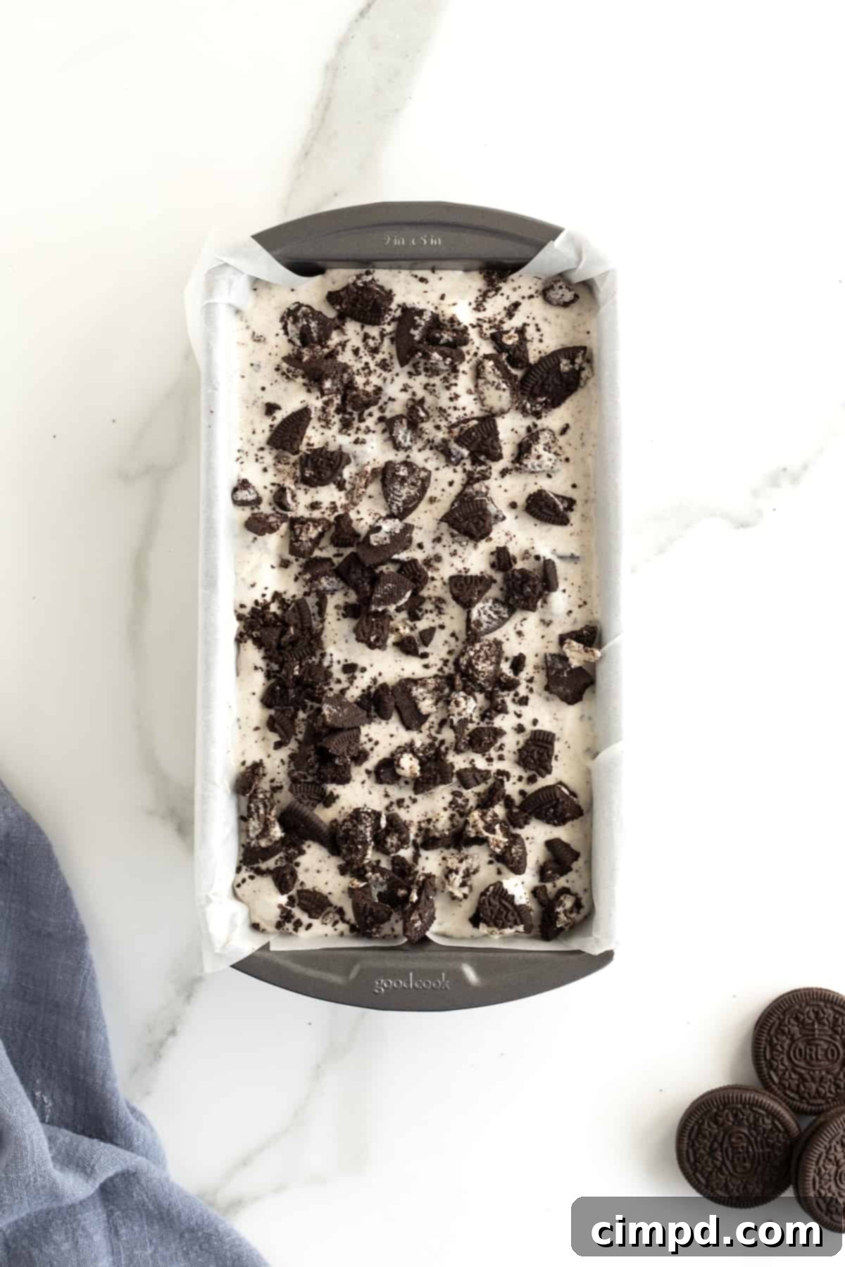 Black and White Bliss 10 The ice cream base beautifully topped with an abundance of crushed Oreo cookies, ready for the freezer in its parchment-lined loaf pan.