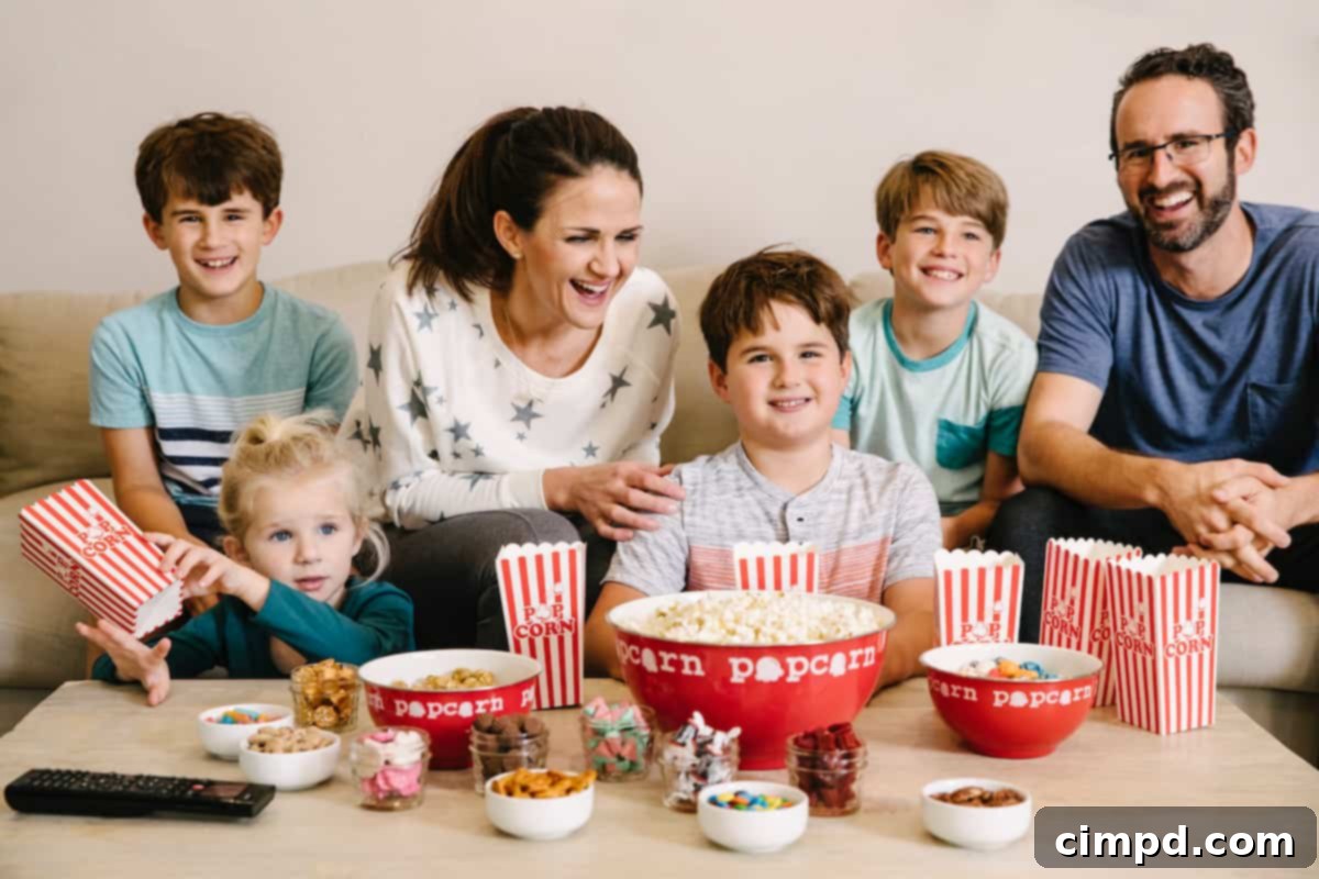 Step Inside Our Dream Pantry 12 Happy family on the couch enjoying family movie night with popcorn and candy on table, demonstrating moderation.