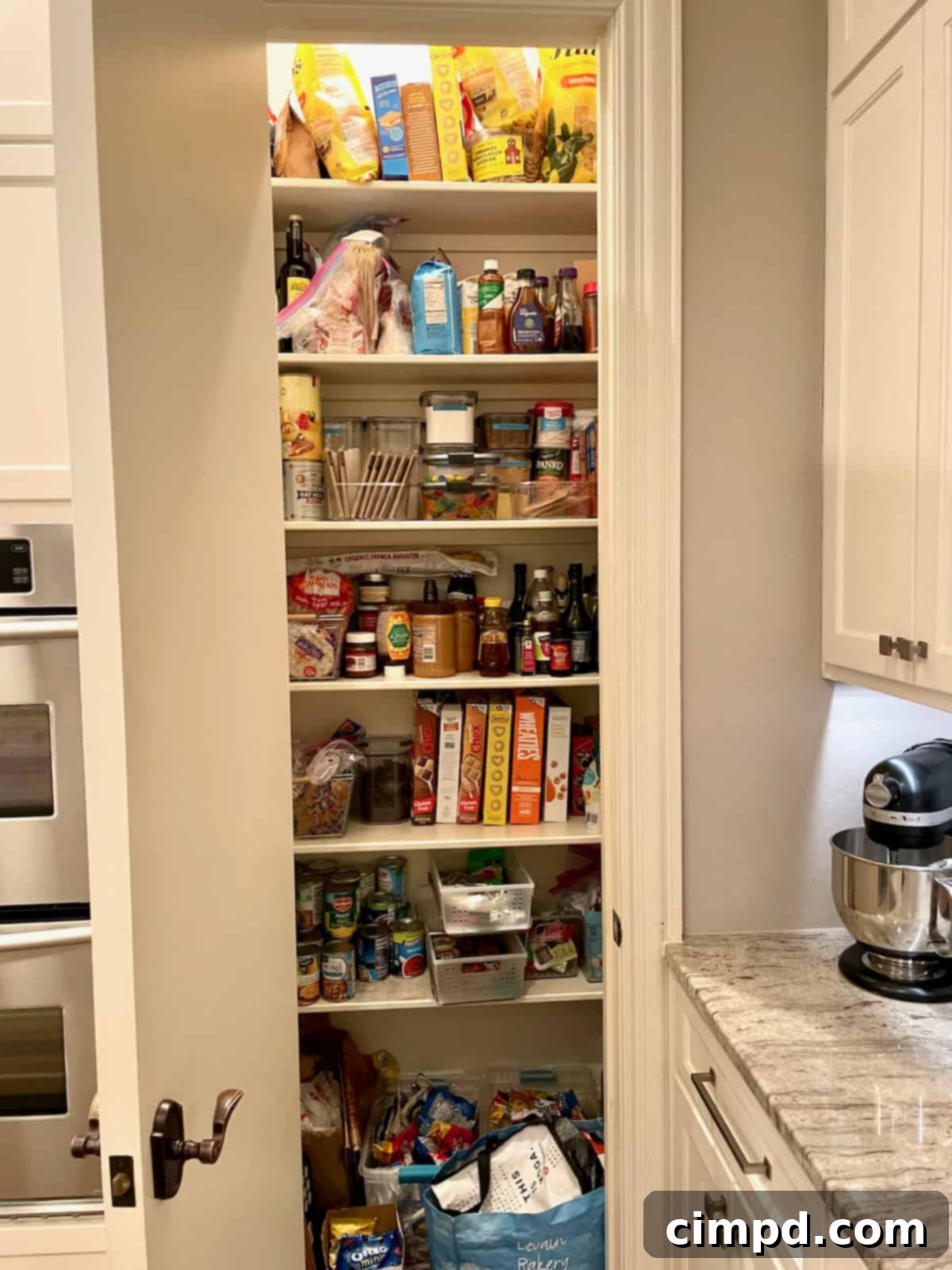 Step Inside Our Dream Pantry 4 Cluttered pantry closet with deep shelves and packaged foods before organization.