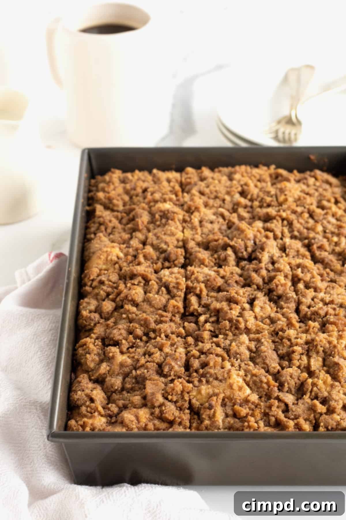 A rectangle metal baking pan of coffee cake, with a golden-brown streusel topping.