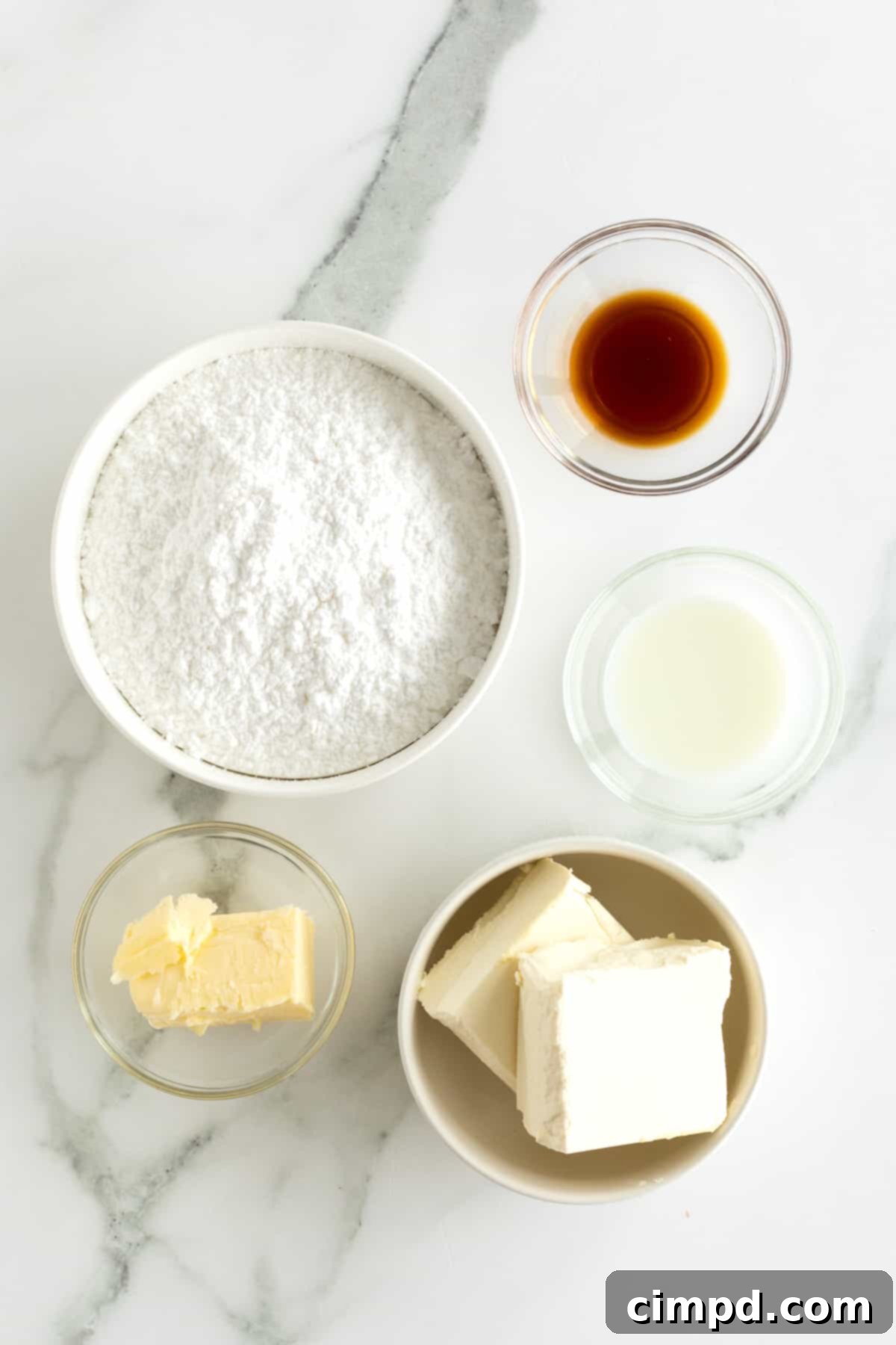 Whip Up Perfect Cream Cheese Frosting 5 Powdered sugar, butter, vanilla extract, milk, and cream cheese in small glass bowls.