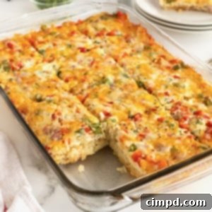 A clear glass baking dish with hash brown breakfast casserole with a slice cut out.