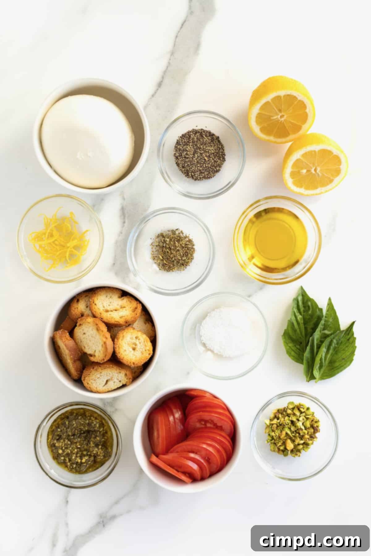 Velvet Burrata Caprese Board 6 A flat lay of all the fresh ingredients needed for the Burrata Caprese Platter, including burrata, tomatoes, basil, pesto, and pistachios.