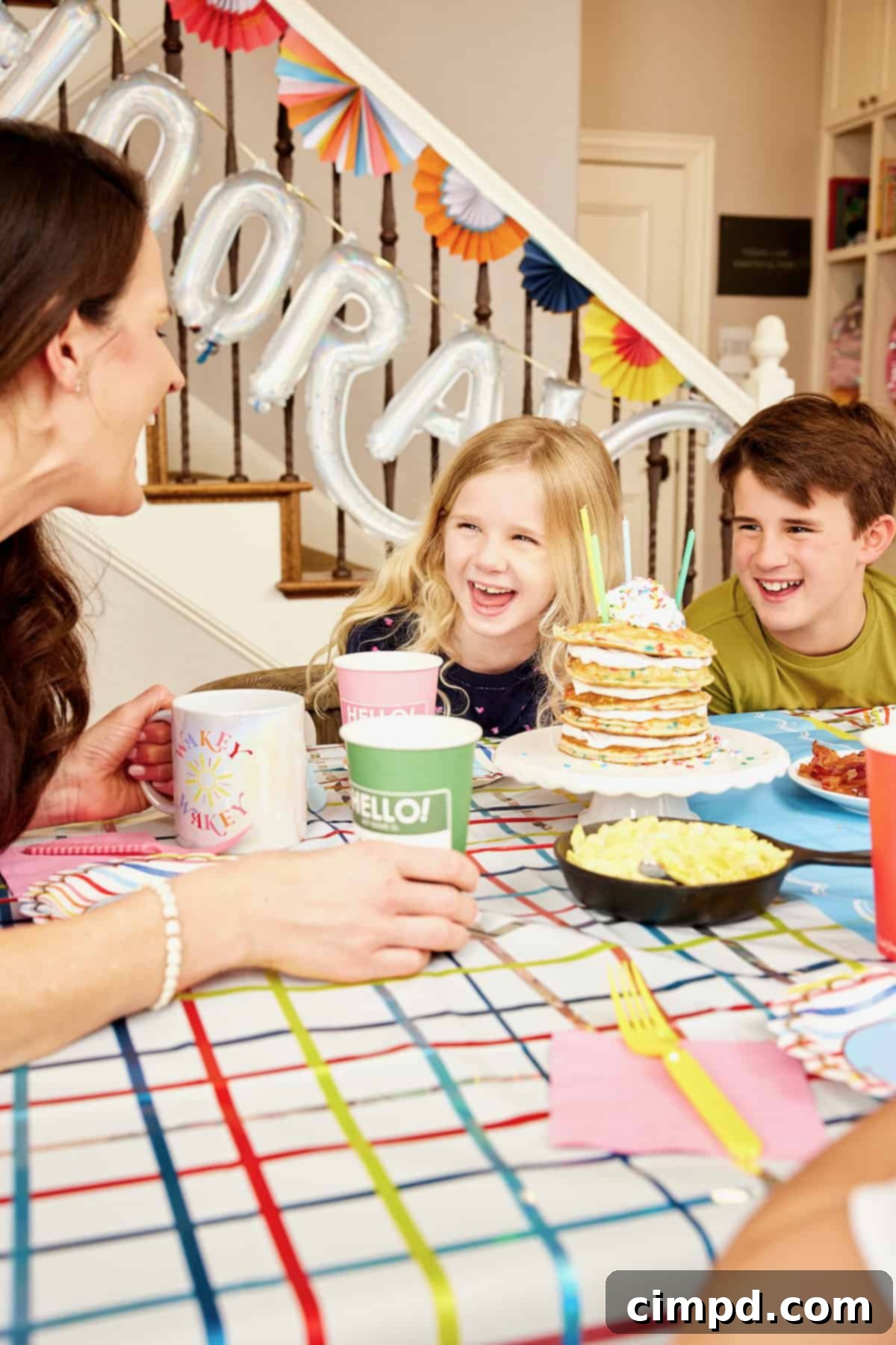 Ignite Your School Year 9 A joyful family portrait of a mother and her four children sharing a festive breakfast on the first day of school, with colorful paper decorations enhancing the celebratory atmosphere.