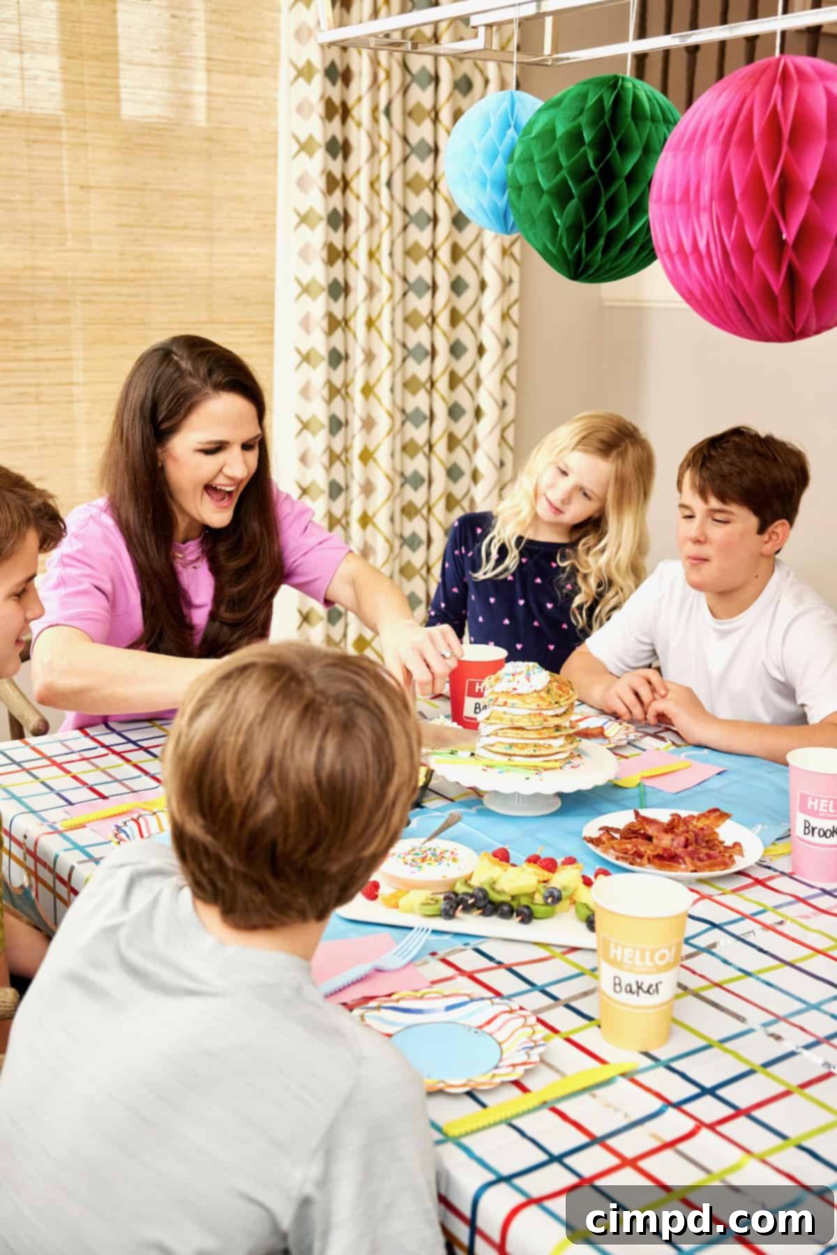 Ignite Your School Year 4 A cheerful family of a mother and four children enjoying a celebratory first-day-of-school breakfast, surrounded by colorful hanging paper decorations.