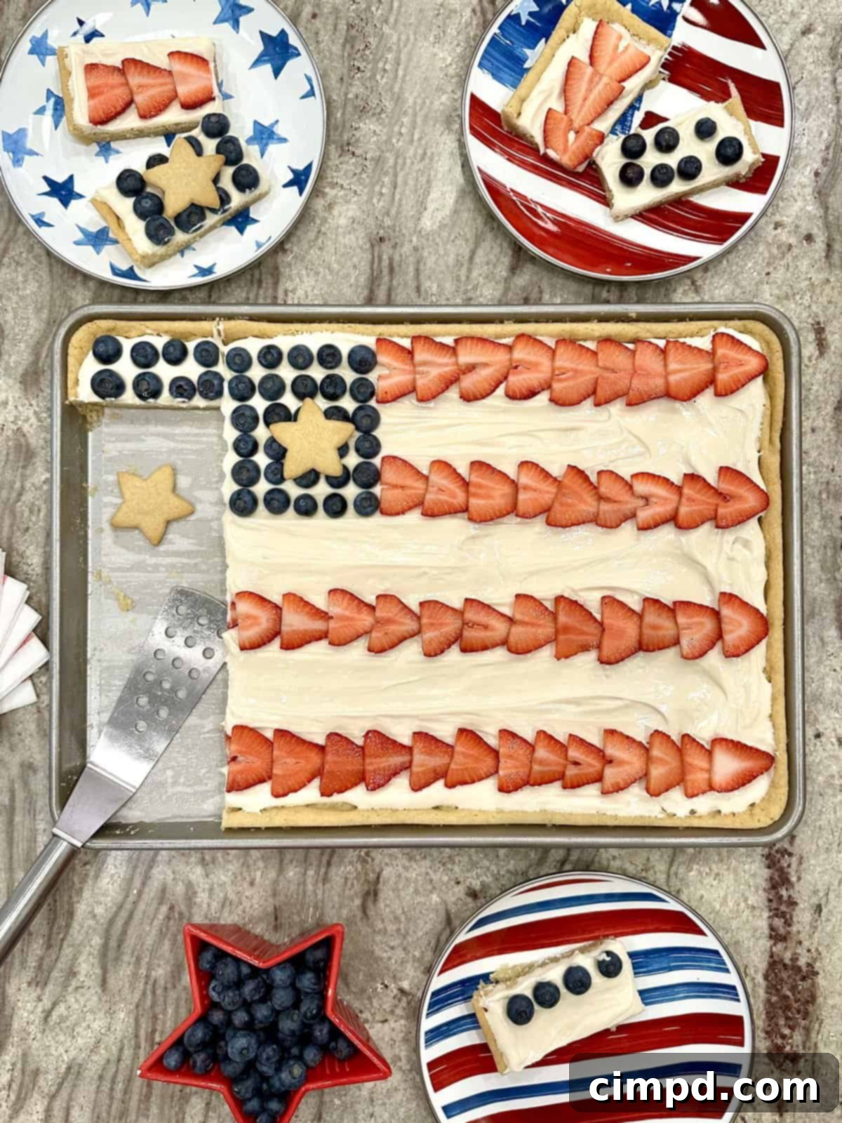 Star-Spangled Fruit Pizza with Cream Cheese Frosting 3 An overhead view of the American Flag Fruit Pizza, showcasing the meticulously arranged strawberries, blueberries, and star cookies on a creamy frosted sugar cookie base.