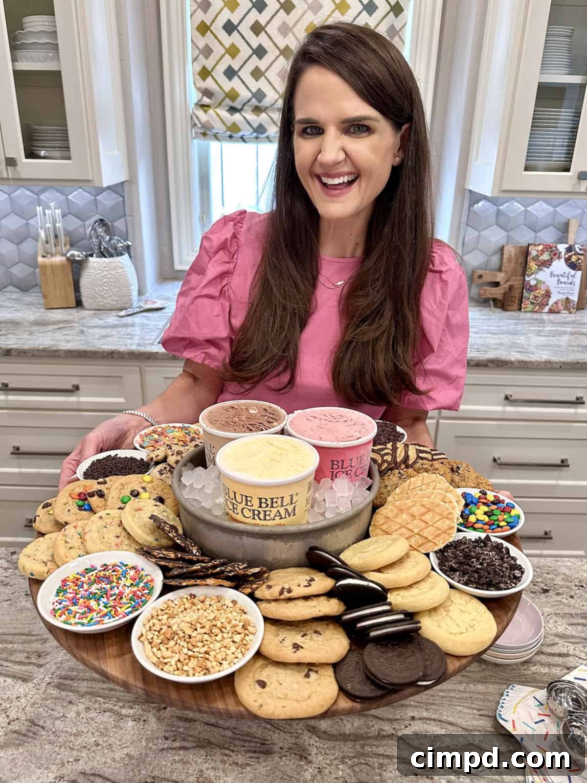 DIY Cookie Ice Cream Sandwich Bar 3 A beautifully arranged wooden board displaying scoops of chocolate, strawberry, and vanilla ice cream, alongside an array of cookies and colorful toppings including mini marshmallows, M&Ms, crushed Oreos, vibrant rainbow sprinkles, Fruity Pebbles, and savory crushed peanuts.