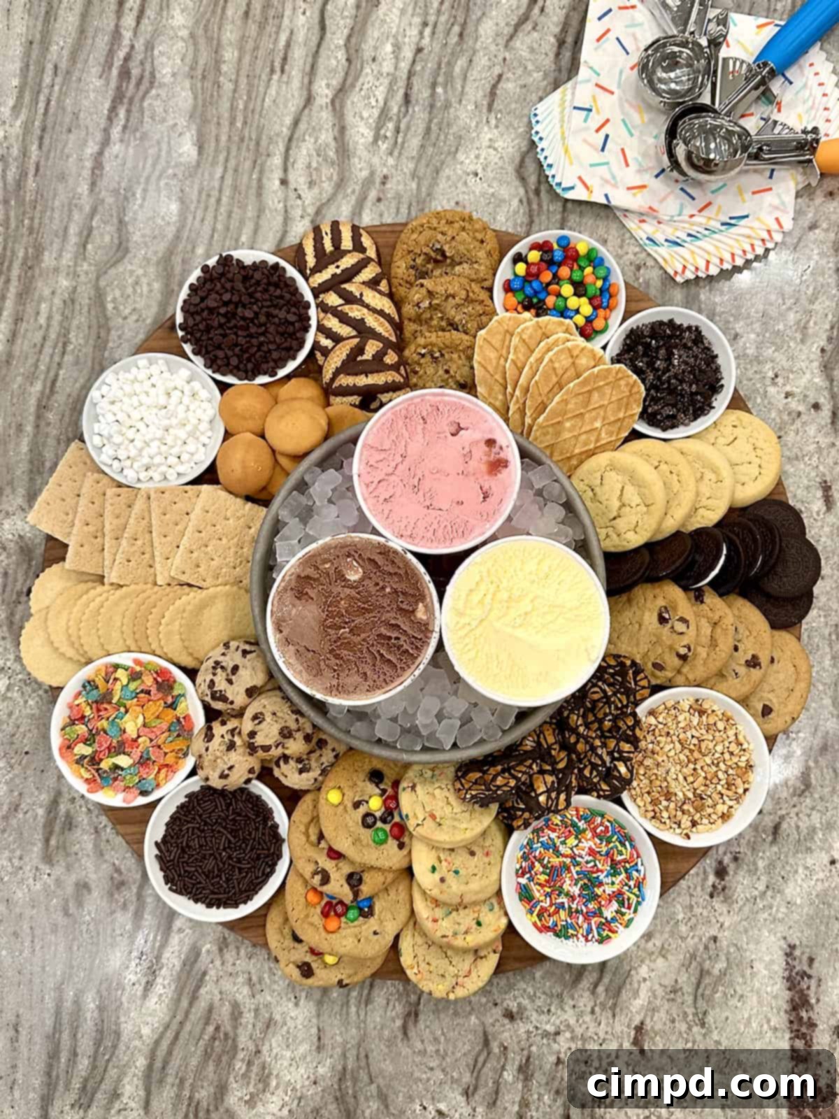 DIY Cookie Ice Cream Sandwich Bar 6 A vibrant wooden board showcasing an inviting spread of chocolate, strawberry, and vanilla ice creams, an assortment of cookies, and colorful toppings including mini marshmallows, M&Ms, crushed Oreos, rainbow sprinkles, Fruity Pebbles, and crushed peanuts, ready for guests to create their own treats.