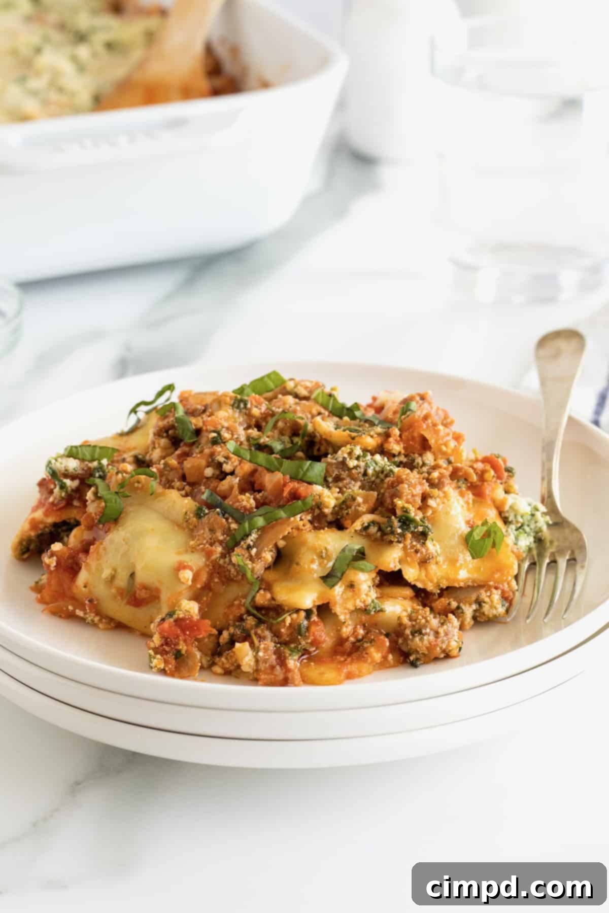 A plate of lasagna ravioli with a fork.