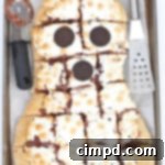 Ghostly Smores Pizza 3 A close-up of a slice of Spooky S'mores Pizza, with melted chocolate and perfectly toasted marshmallows.