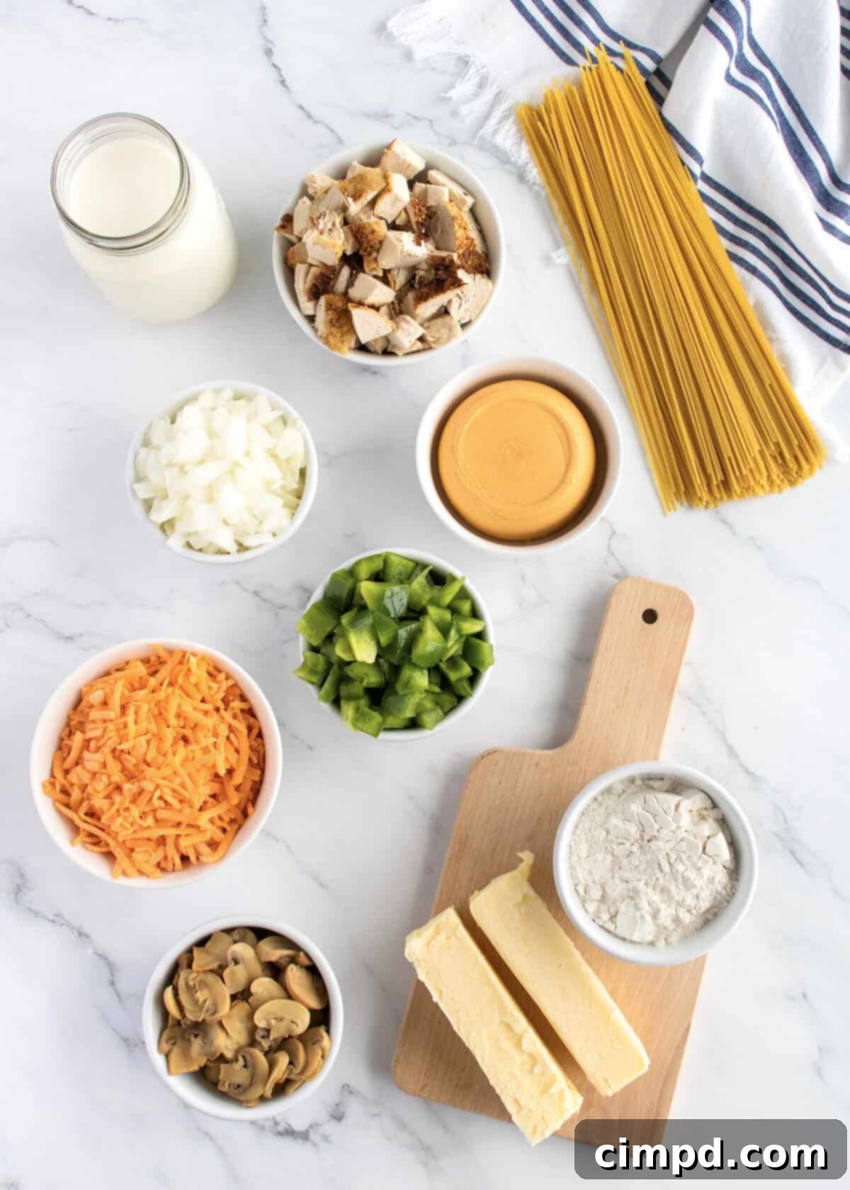 Homestyle Creamy Chicken Bake 4 Ingredients to make chicken tetrazzini in small glass dishes on a white marble counter.