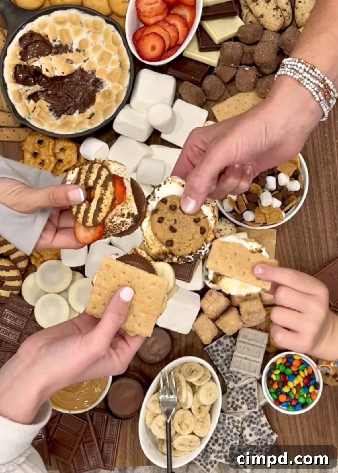 Your Guide to an Epic Smores Board 4 Four distinct s'mores creations arranged on a white background: a classic s'more, a s'more with Fudge Stripe Cookies and a strawberry slice, a decadent s'more with chocolate chip cookies, Cookies 'n' Creme chocolate, and M&M's Minis, and a gourmet s'more featuring graham crackers, white chocolate with caramel, and strawberry slices.